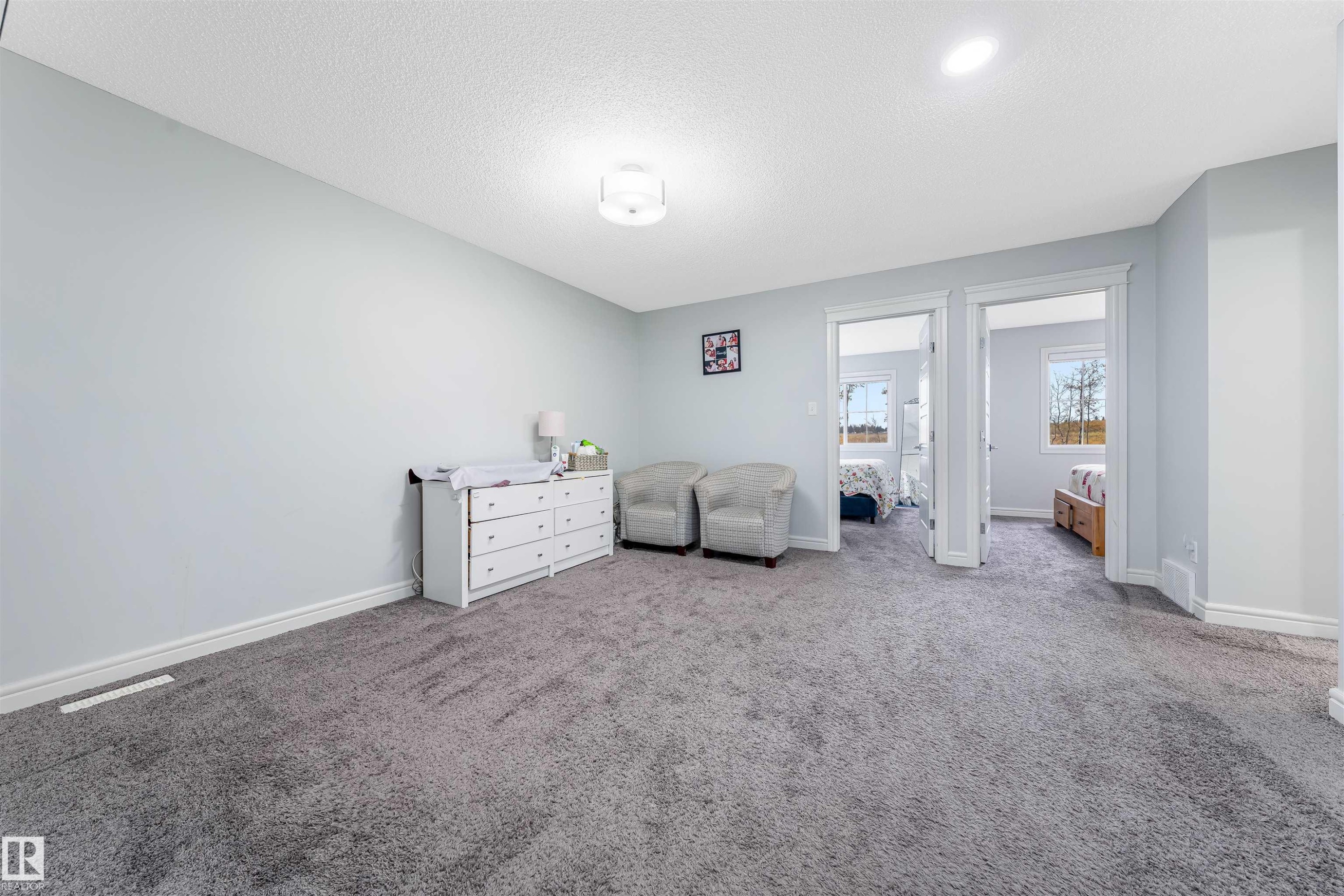 Spacious carpeted room featuring light gray walls, white trim, and recessed lighting - 1024 Daniels Loop, Edmonton, AB - Indoor Photo Showing Bedroom