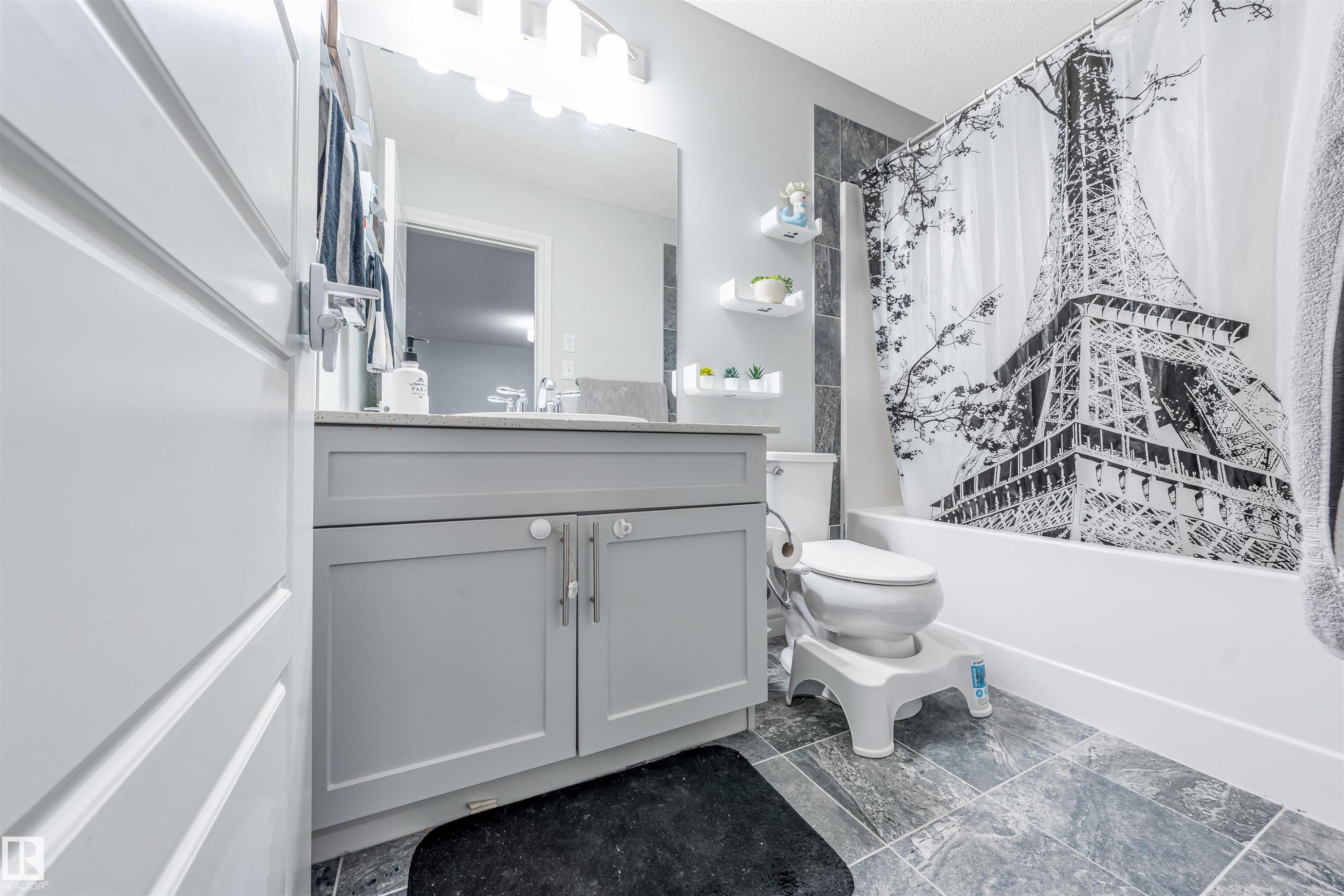 Full bathroom featuring a single vanity with gray cabinetry, a rectangular sink, and a light-colored countertop - 1024 Daniels Loop, Edmonton, AB - Indoor Photo Showing Bathroom