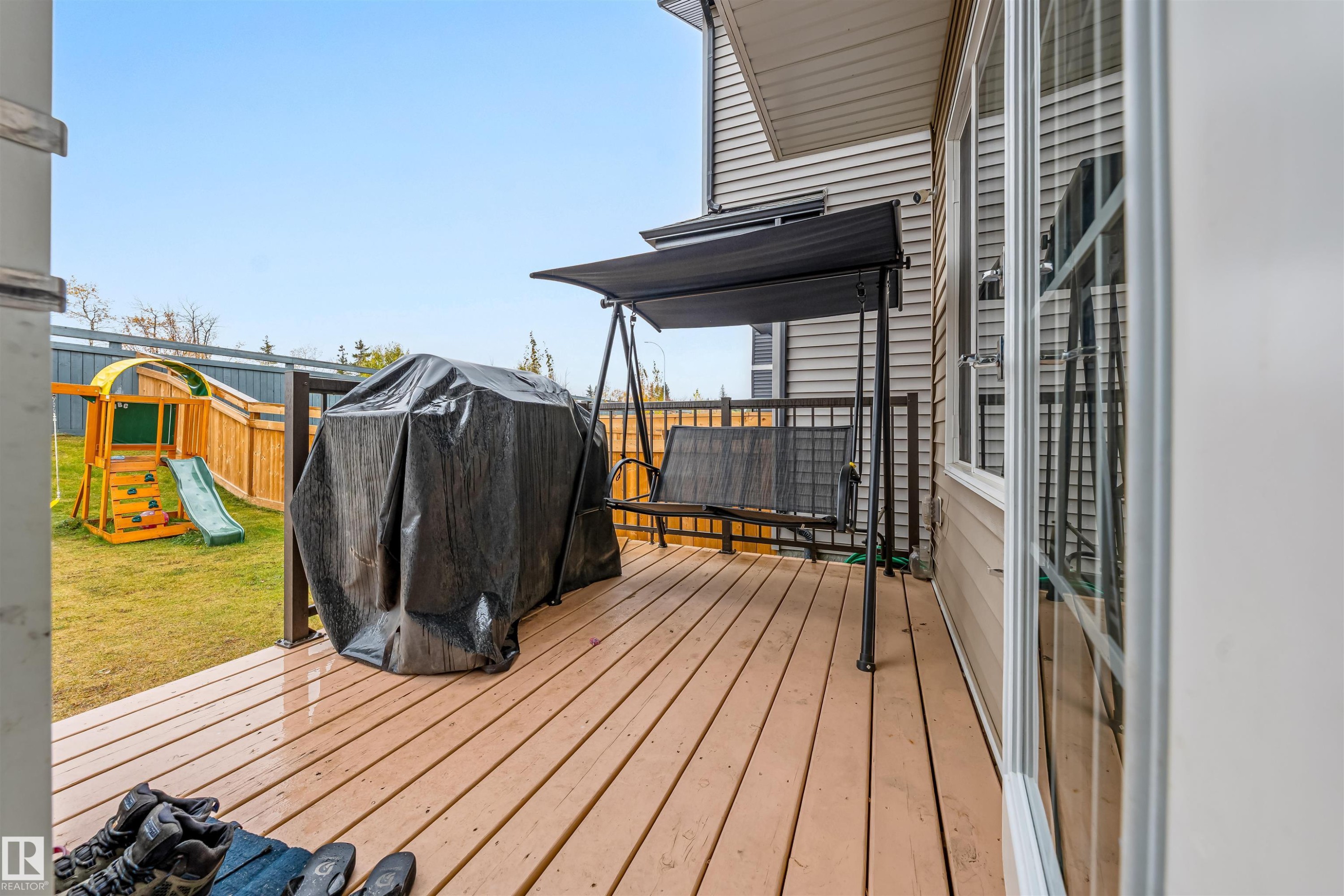Wood-finish deck with dark railings and a beige vinyl-sided exterior - 1024 Daniels Loop, Edmonton, AB - Outdoor With Deck Patio Veranda With Exterior