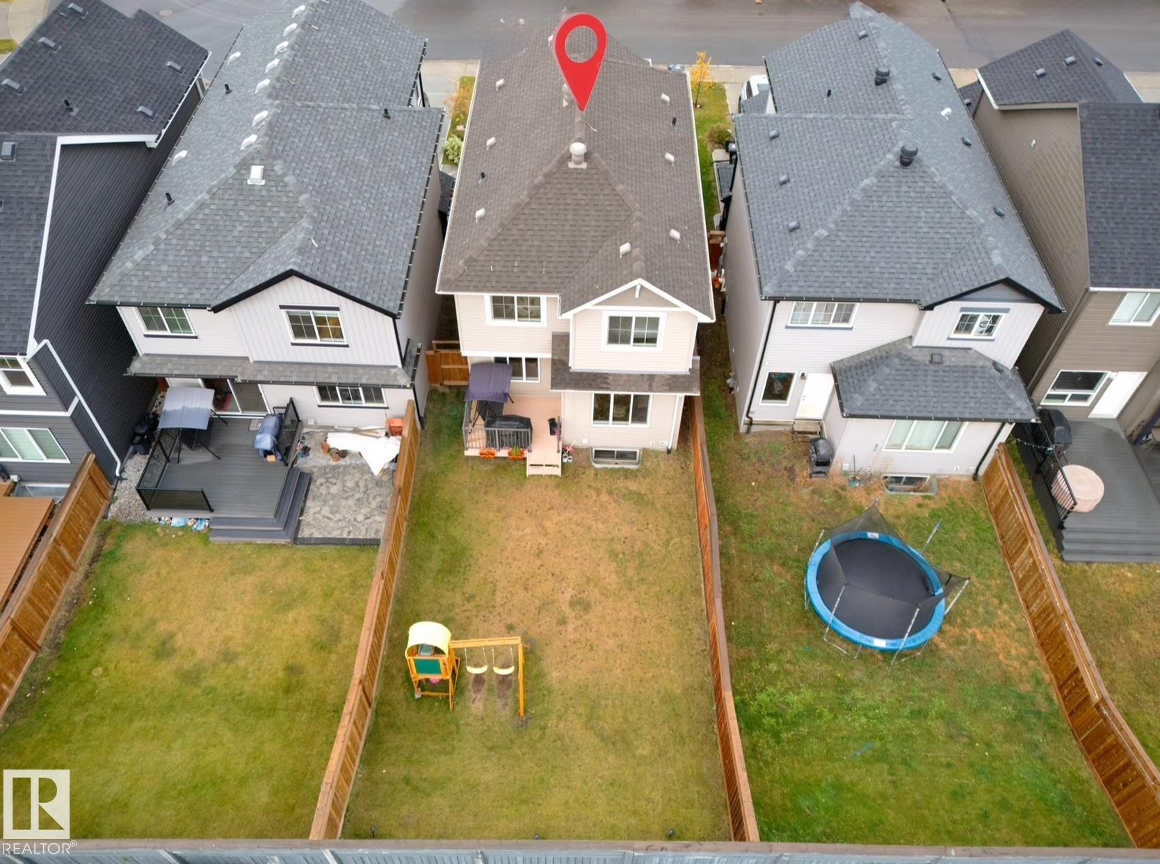 Rear exterior featuring a multi-level deck, ground-level patio, and a spacious grassy yard - 1024 Daniels Loop, Edmonton, AB - Outdoor