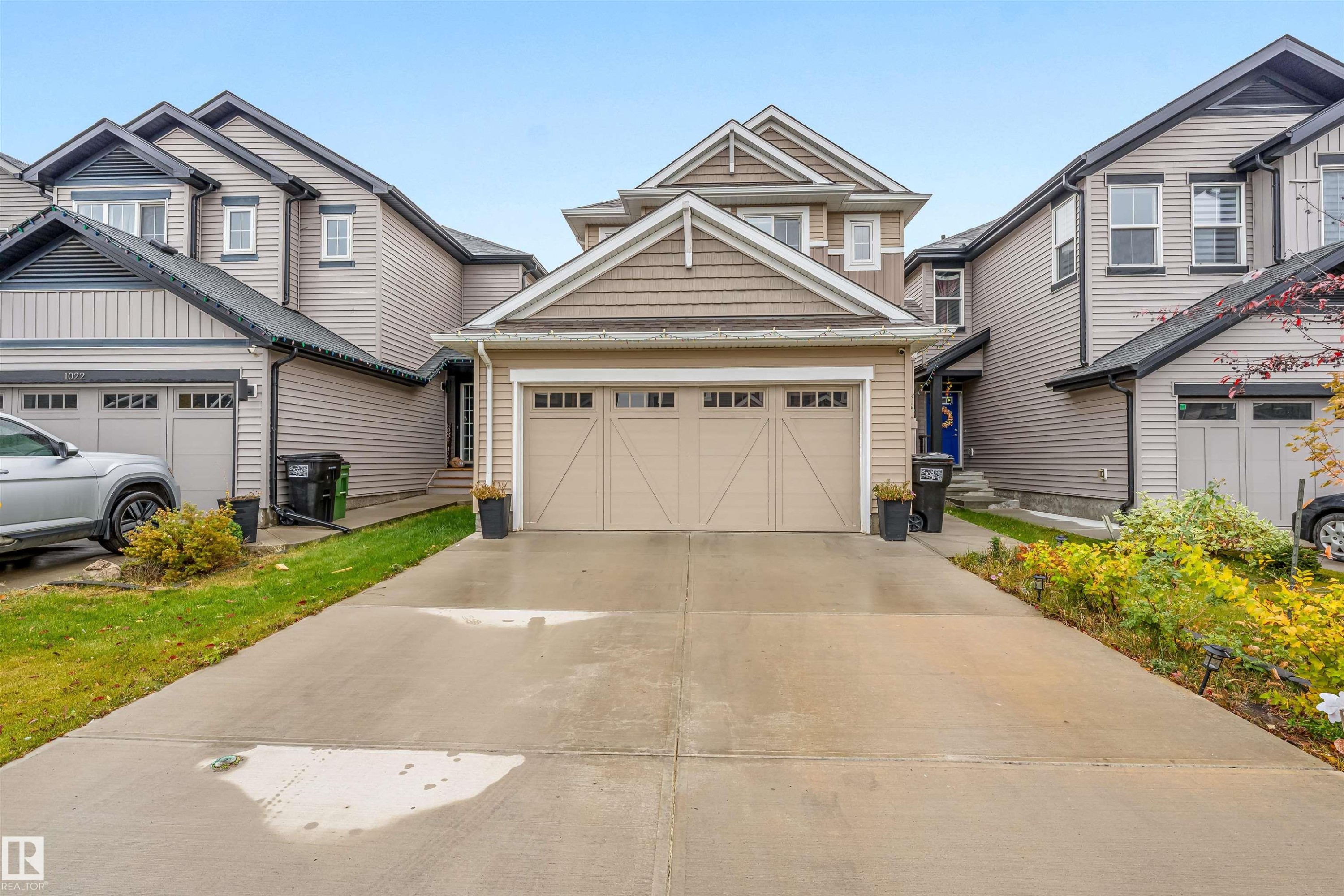 Modern residential exterior featuring a tan garage door with window inserts, complementary siding, and a shingled roof - 1024 Daniels Loop, Edmonton, AB - Outdoor With Facade
