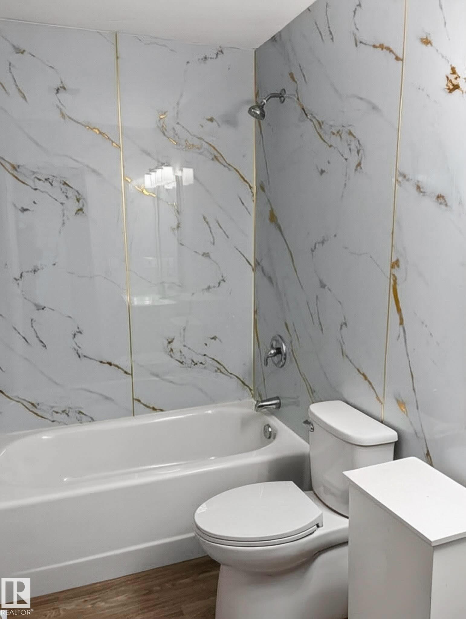 Contemporary bathroom featuring a white bathtub, polished chrome fixtures, and a toilet - 13833 24 Street W, Edmonton, AB - Indoor Photo Showing Bathroom