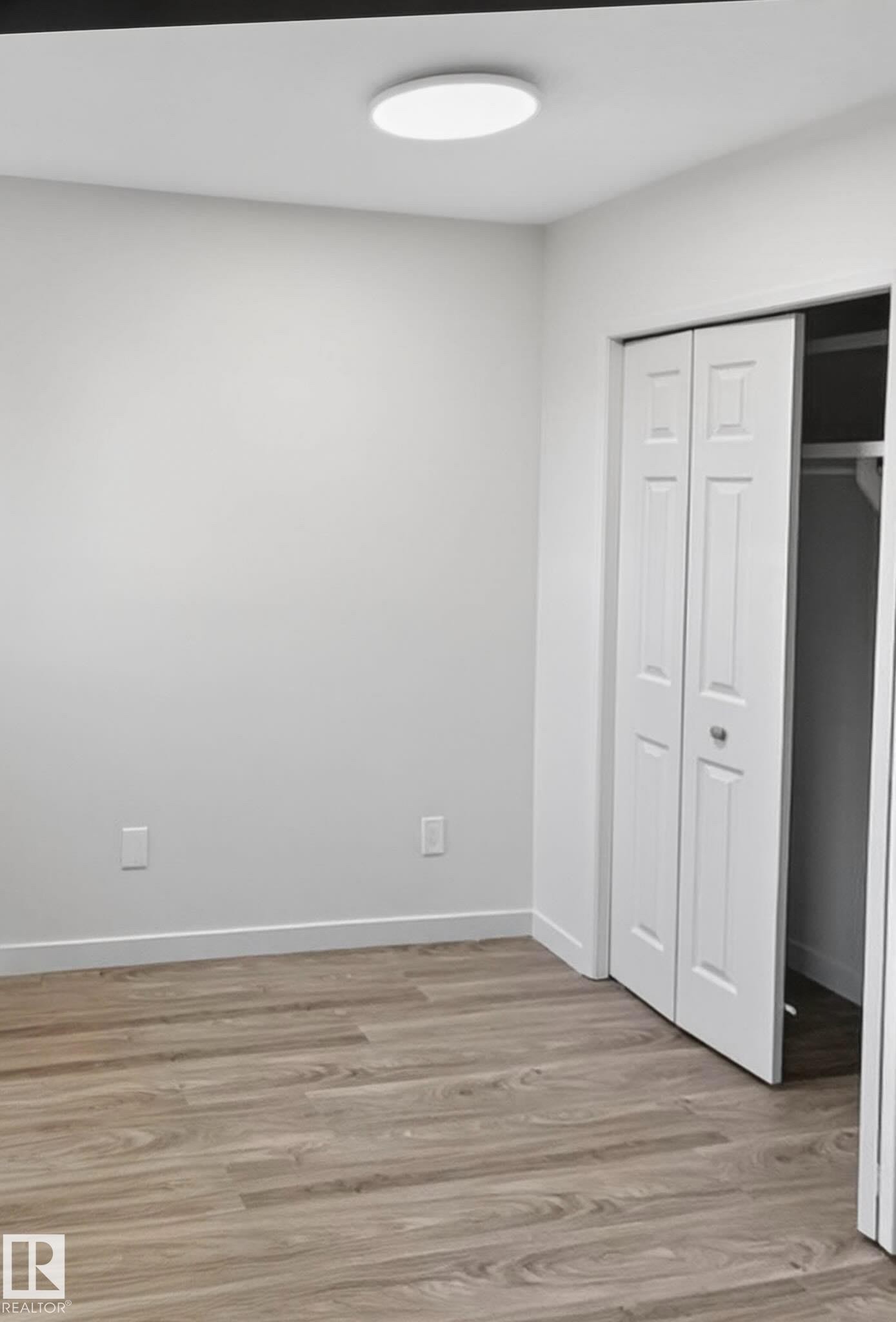 Room featuring wood-finish flooring, white walls, and a recessed ceiling light - 13833 24 Street W, Edmonton, AB - Indoor Photo Showing Other Room