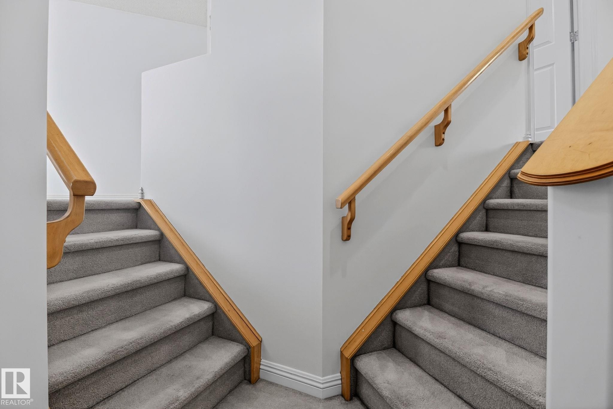 Central staircase featuring carpeted steps and light wood handrails - 978 Rutherford Road Sw, Edmonton, AB - Indoor Photo Showing Other Room