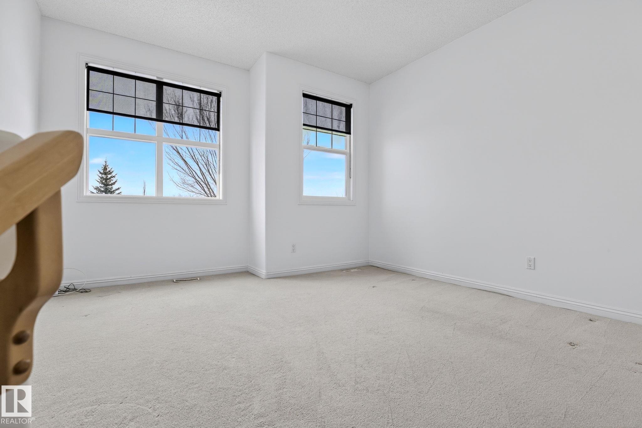 Light-filled room featuring two windows with dark roller shades - 978 Rutherford Road Sw, Edmonton, AB - Indoor Photo Showing Other Room