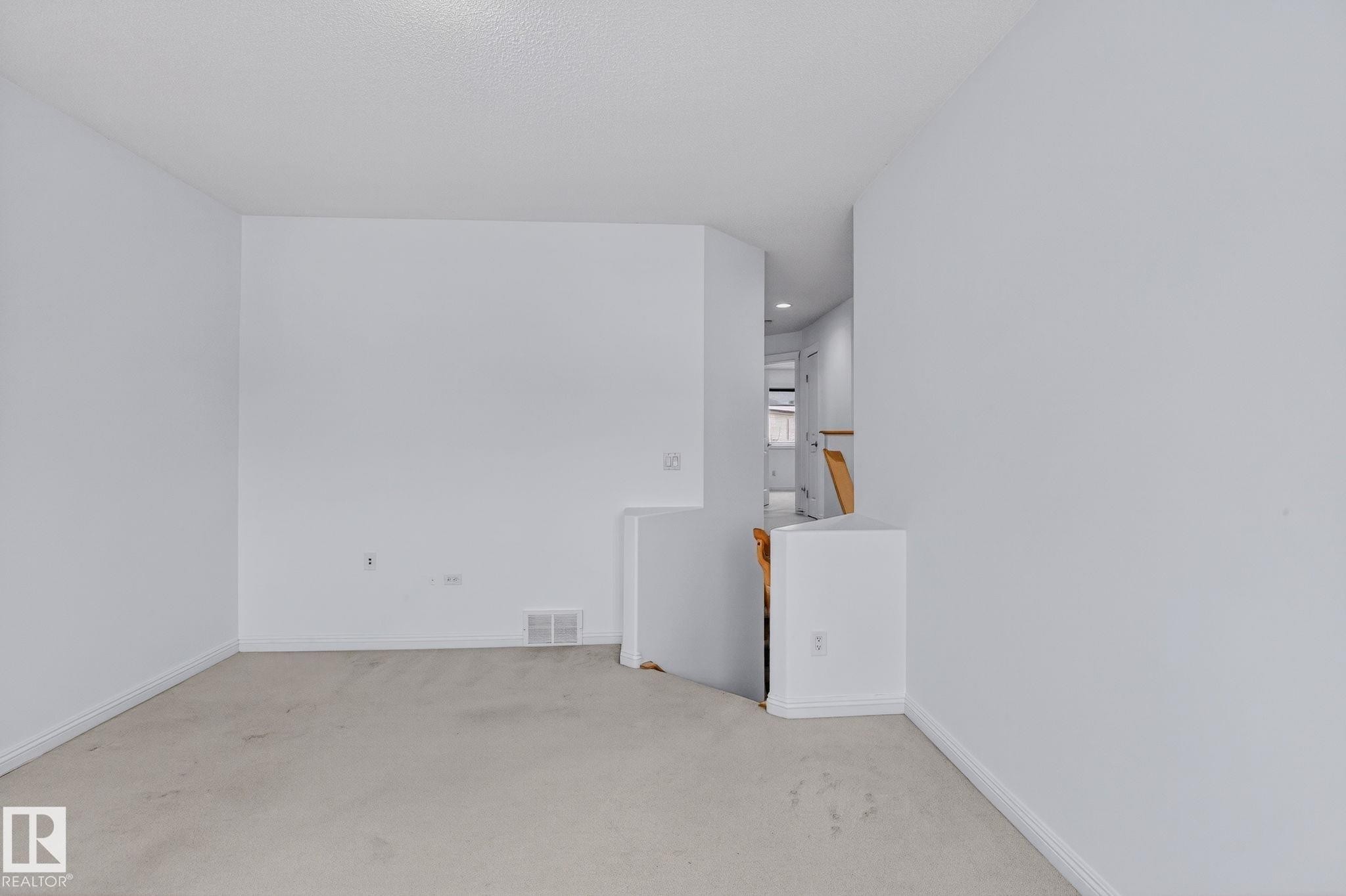Open interior space featuring light-toned carpeting and white wall finishes - 978 Rutherford Road Sw, Edmonton, AB - Indoor Photo Showing Other Room