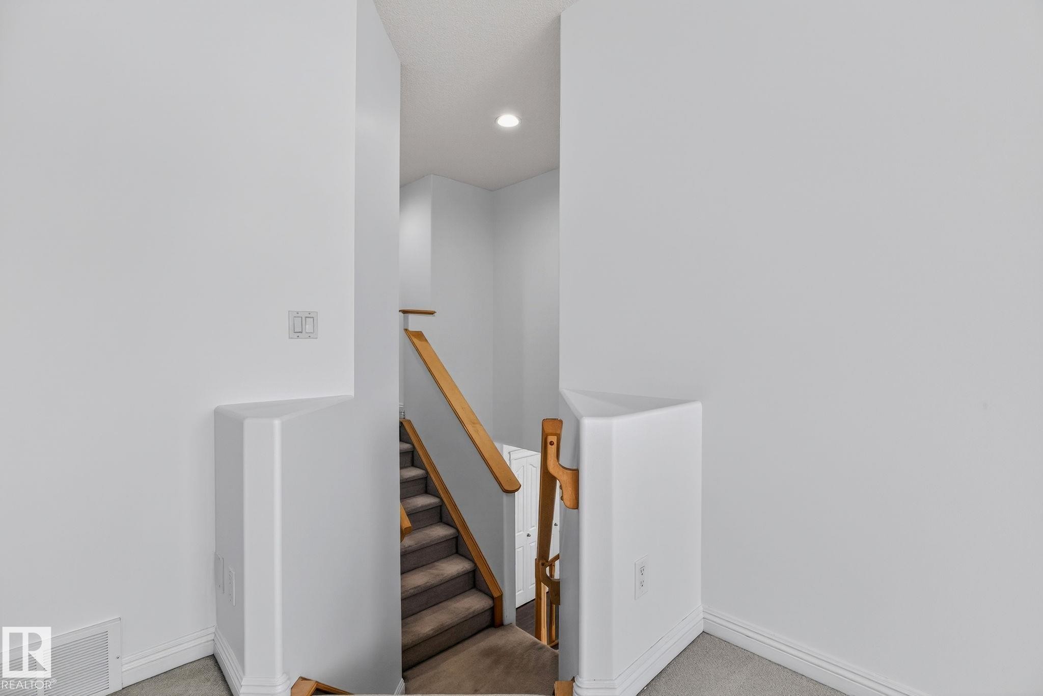 Staircase featuring carpeted treads, wood-finish handrails, and a recessed ceiling light - 978 Rutherford Road Sw, Edmonton, AB - Indoor Photo Showing Other Room