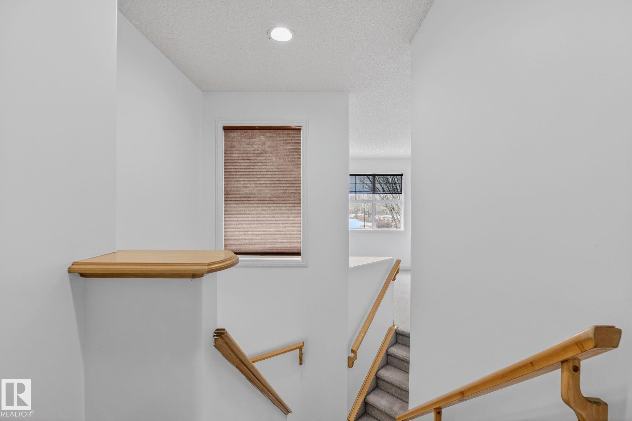 Stairwell featuring light wood handrails, carpeted treads, and a recessed ceiling light - 978 Rutherford Road Sw, Edmonton, AB - Indoor Photo Showing Other Room
