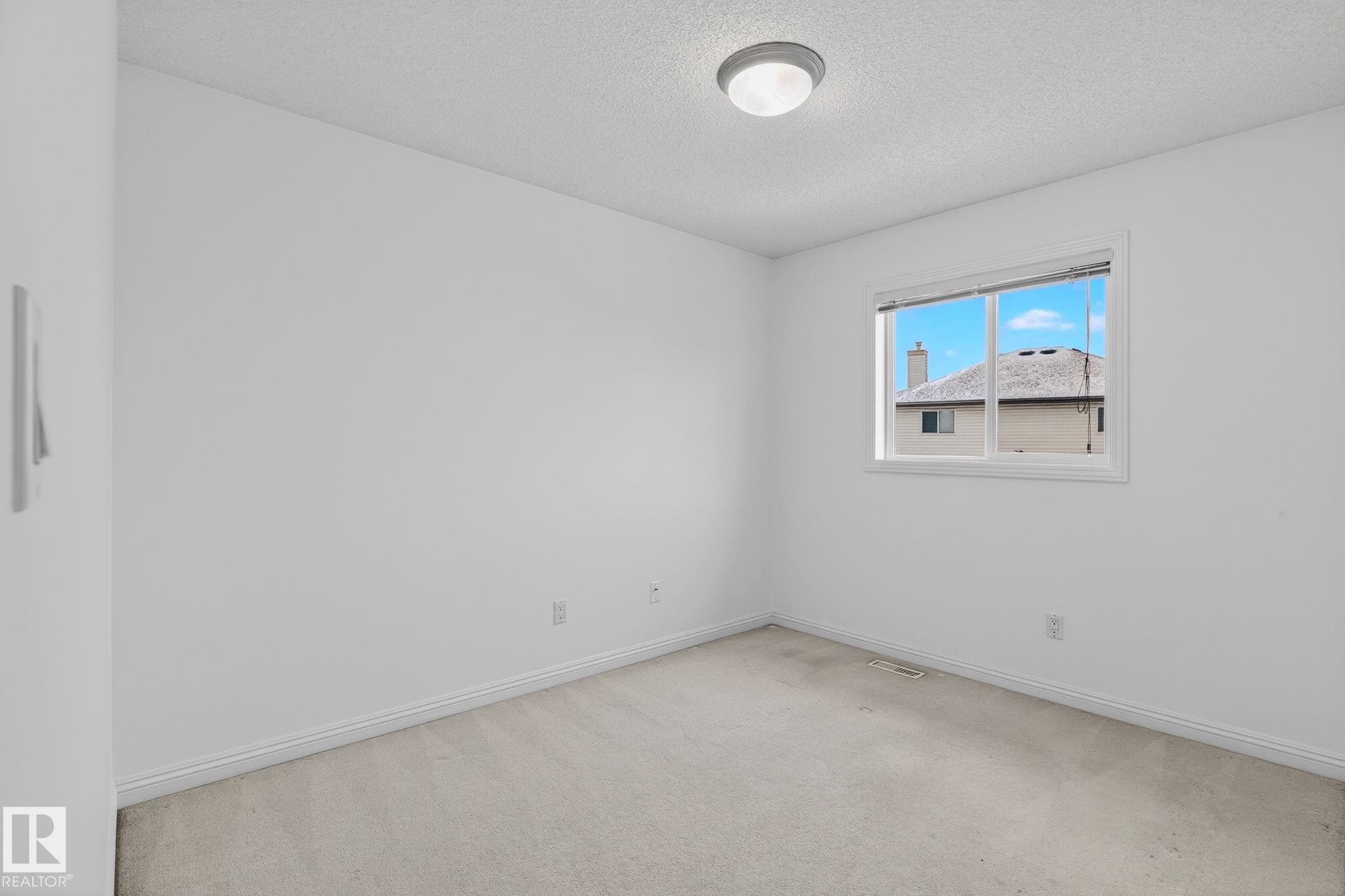Neutral-toned room featuring a single window, ceiling-mounted light fixture, and light-colored carpeting - 978 Rutherford Road Sw, Edmonton, AB - Indoor Photo Showing Other Room