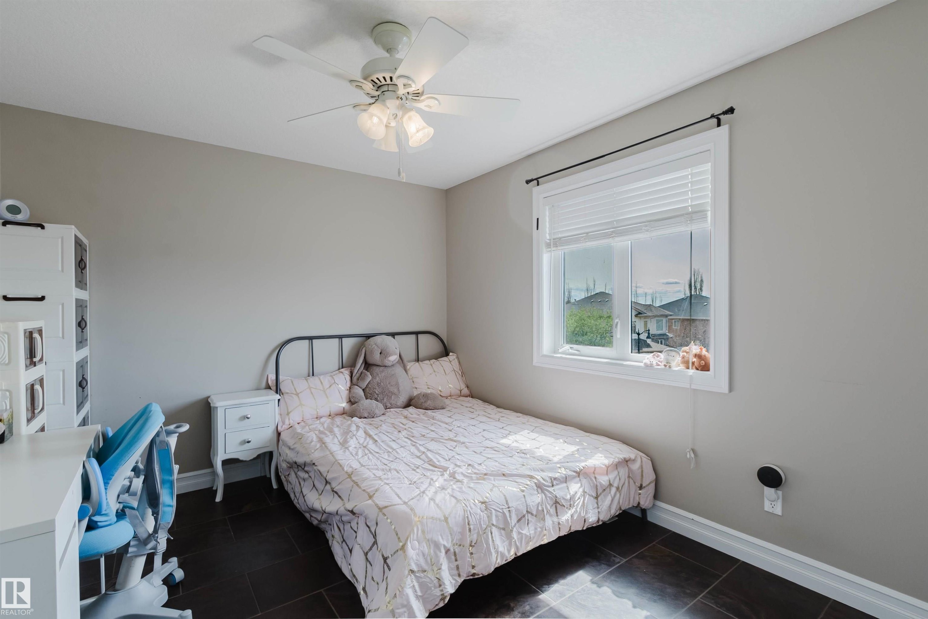 Room featuring a ceiling fan with integrated lighting, a white window frame with blinds, and dark tile flooring - 3412 Macneil Link, Edmonton, AB - Indoor Photo Showing Bedroom