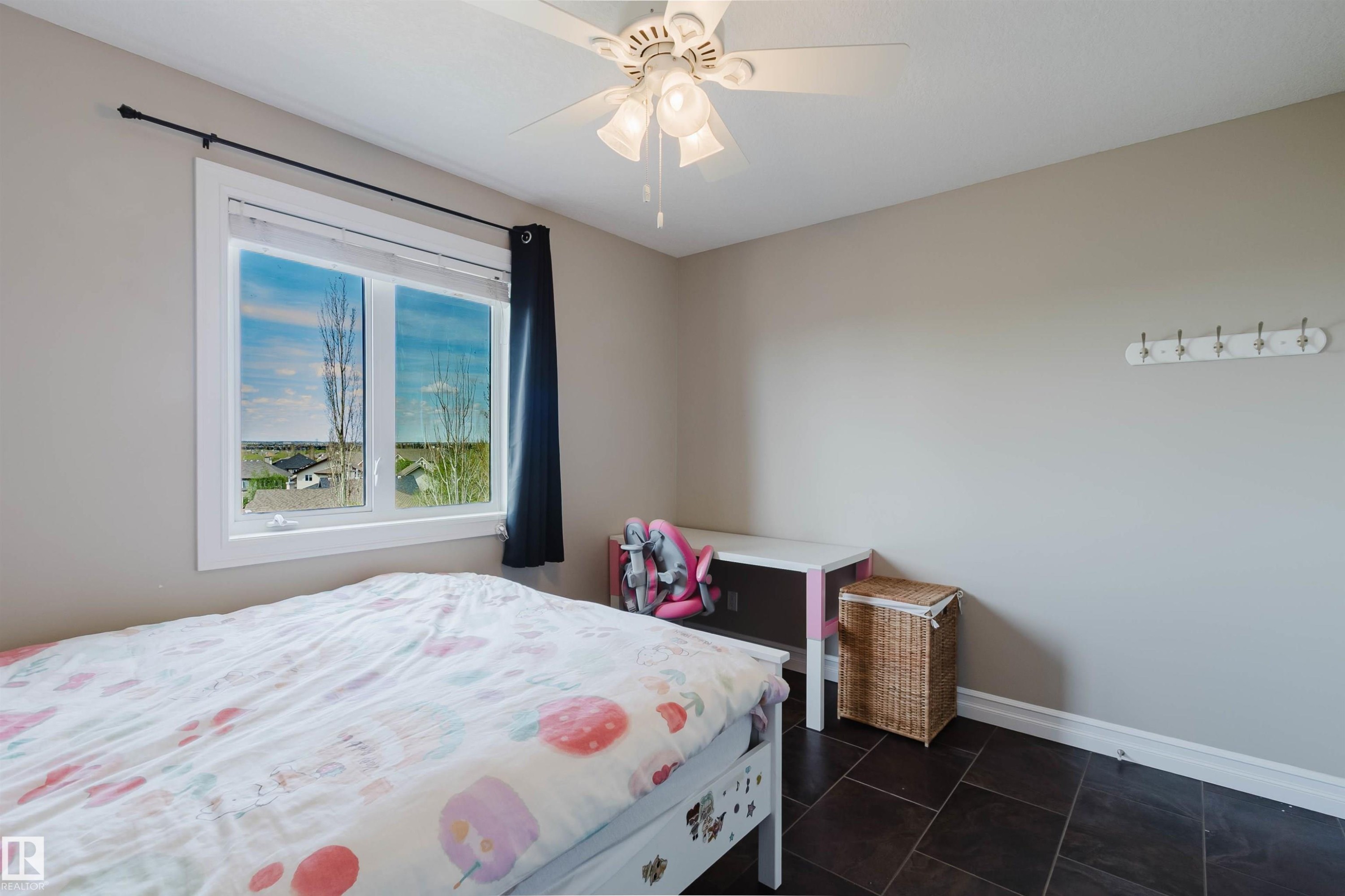 Room featuring dark tile flooring, neutral wall paint, and a white ceiling fan with light fixture - 3412 Macneil Link, Edmonton, AB - Indoor Photo Showing Bedroom