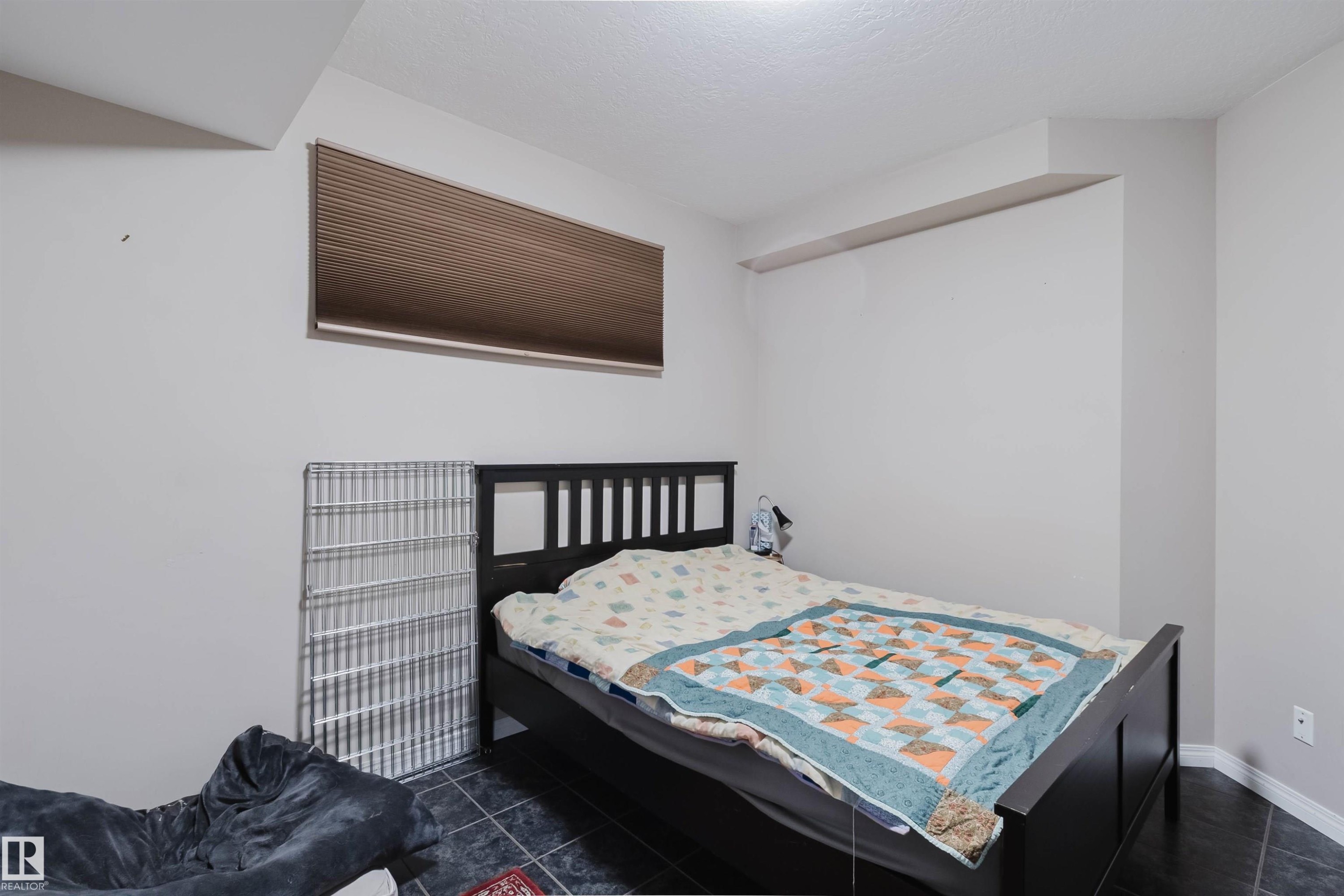 Room with dark tile flooring, white walls, and a single horizontal window with brown blinds - 3412 Macneil Link, Edmonton, AB - Indoor Photo Showing Bedroom