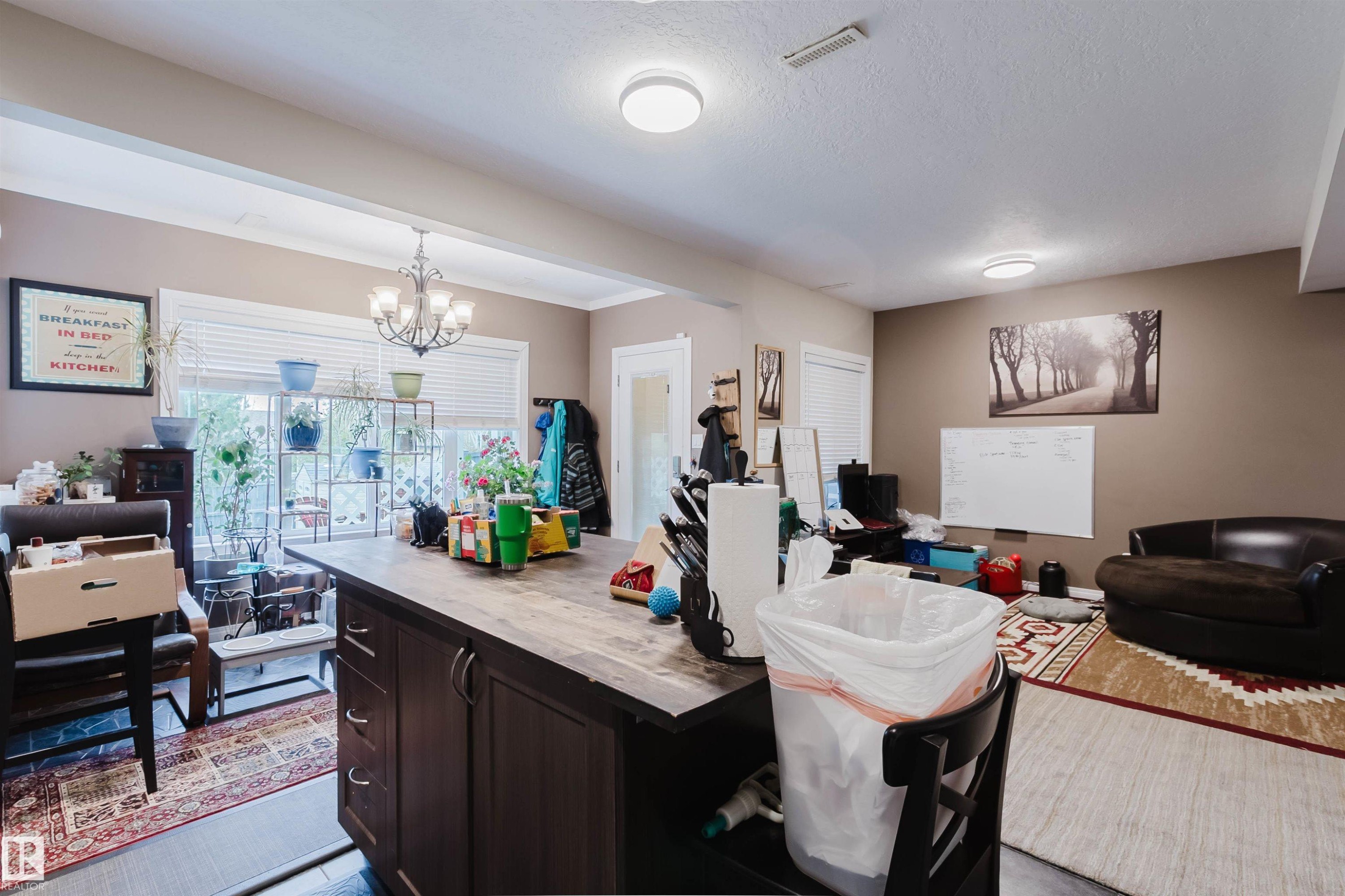 Spacious interior featuring a large central island with storage, recessed lighting, crown molding, and multiple windows providing natural light - 3412 Macneil Link, Edmonton, AB - Indoor