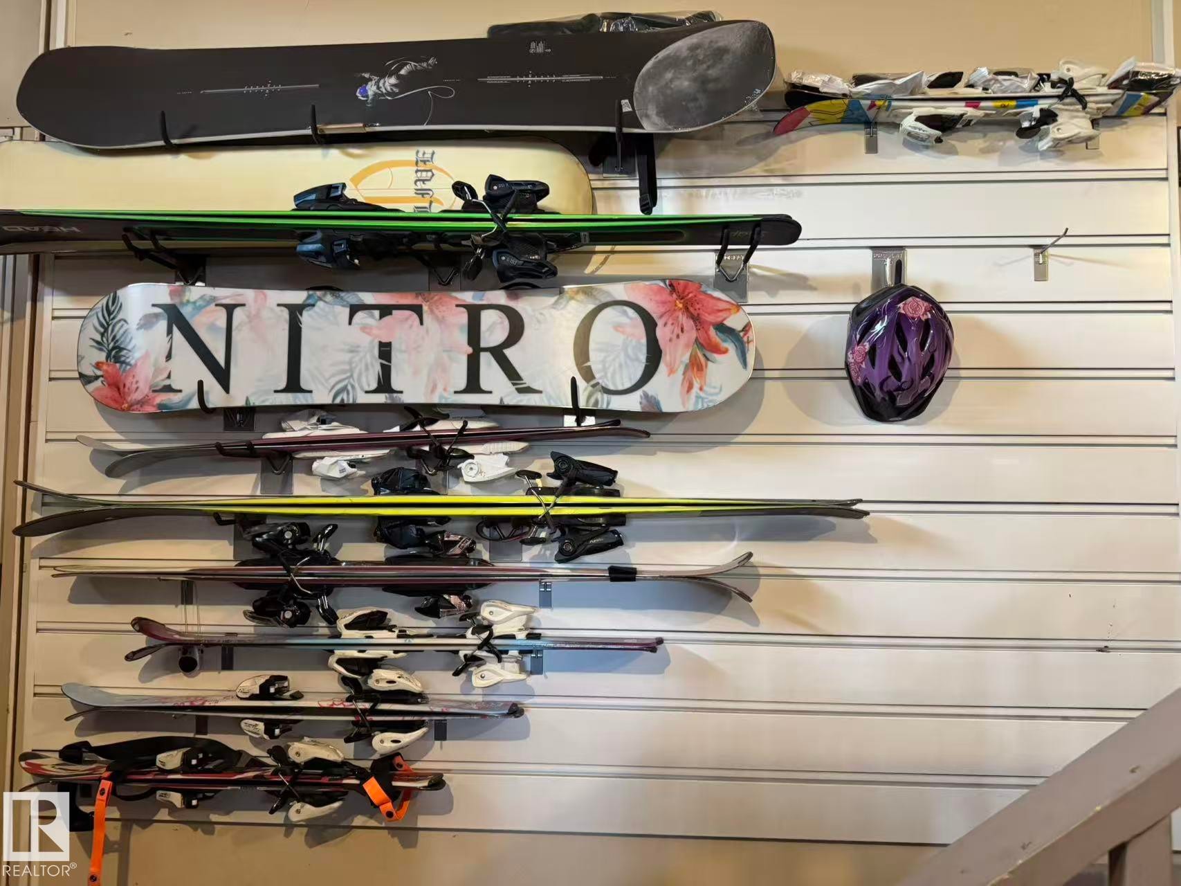 White slatwall storage system with multiple horizontal tracks and various hook attachments, providing versatile organization - 3412 Macneil Link, Edmonton, AB - Indoor Photo Showing Other Room