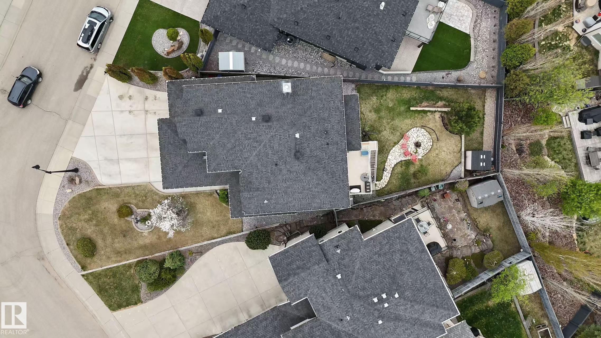 Expansive property featuring a multi-level asphalt shingle roofline, concrete driveway, and front lawn with mature landscaping - 3412 Macneil Link, Edmonton, AB - Outdoor