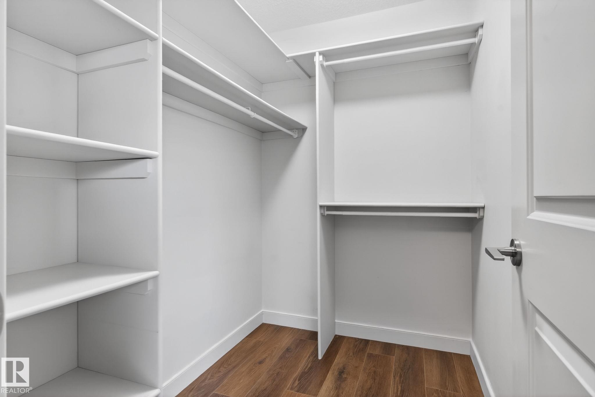 Customized closet system featuring multiple shelving units and clothing rods - 11 450 Mcconachie Way, Edmonton, AB - Indoor With Storage