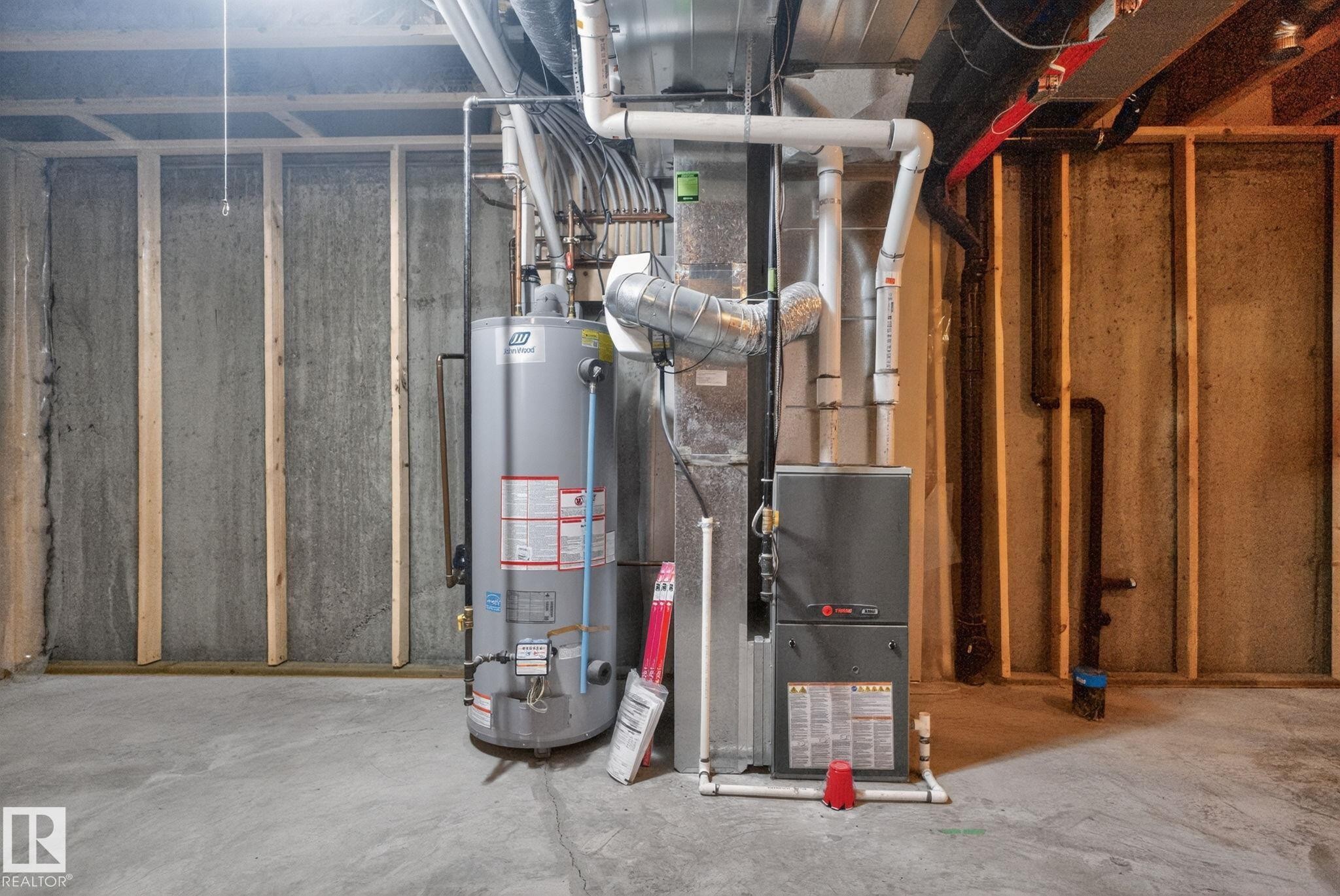 Utility area featuring a water heater and furnace installation - 11 450 Mcconachie Way, Edmonton, AB - Indoor Photo Showing Basement