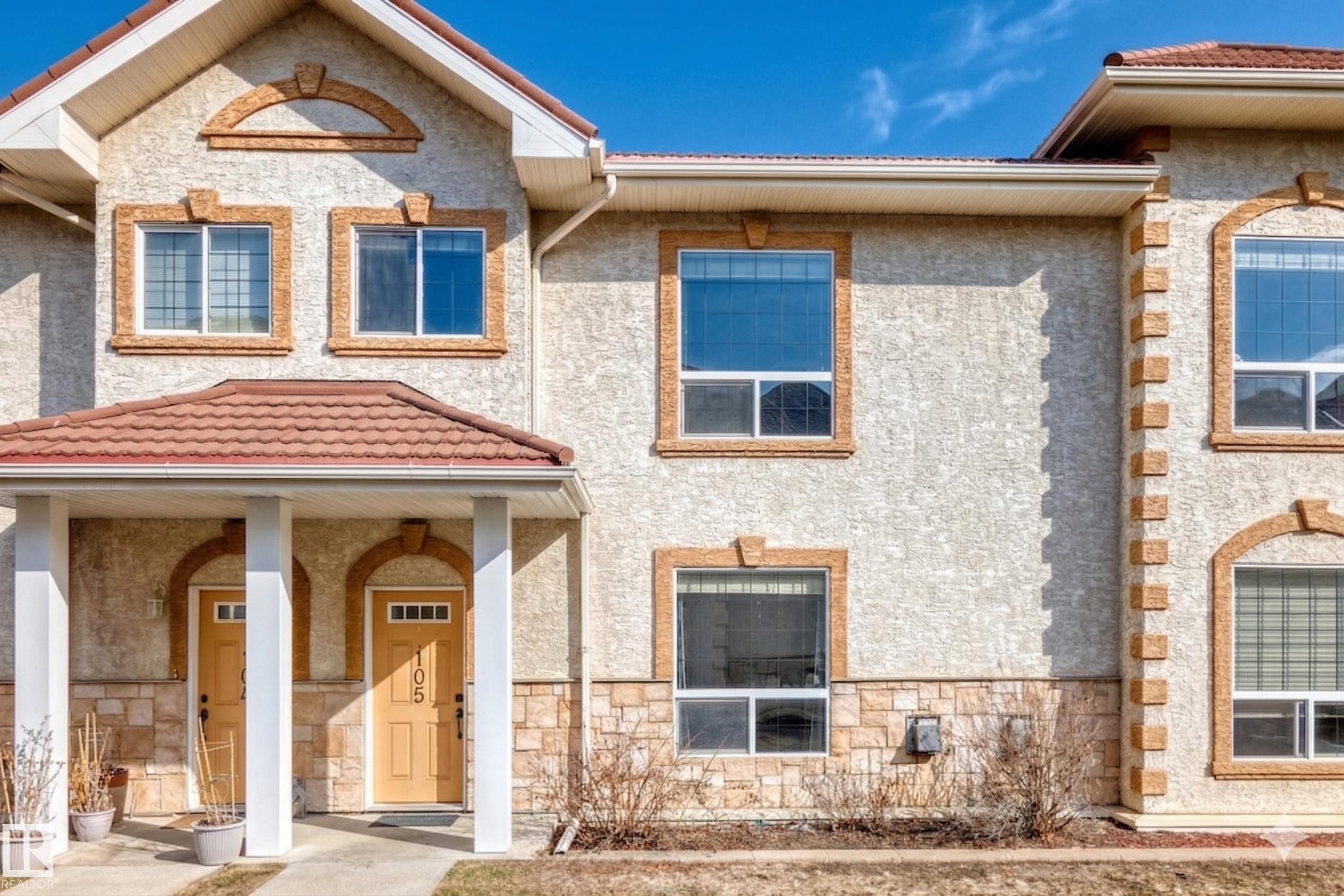 Stucco exterior with stone accents and a terracotta-style tiled roof - 105 13825 155 Avenue, Edmonton, AB - Outdoor With Facade