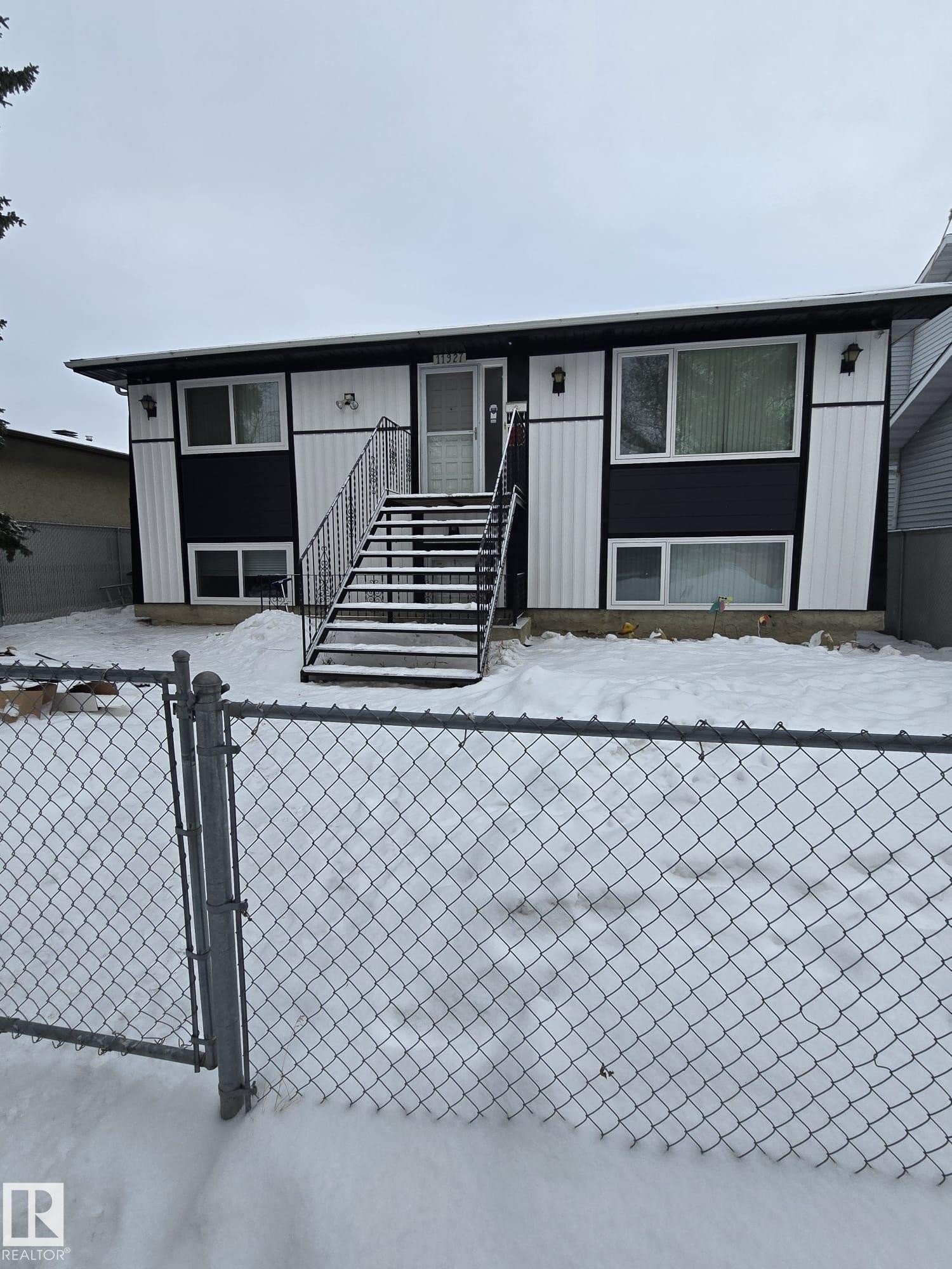 Split-level exterior featuring a black and white facade with vertical siding accents - 11927 85 Street Nw, Edmonton, AB - Outdoor