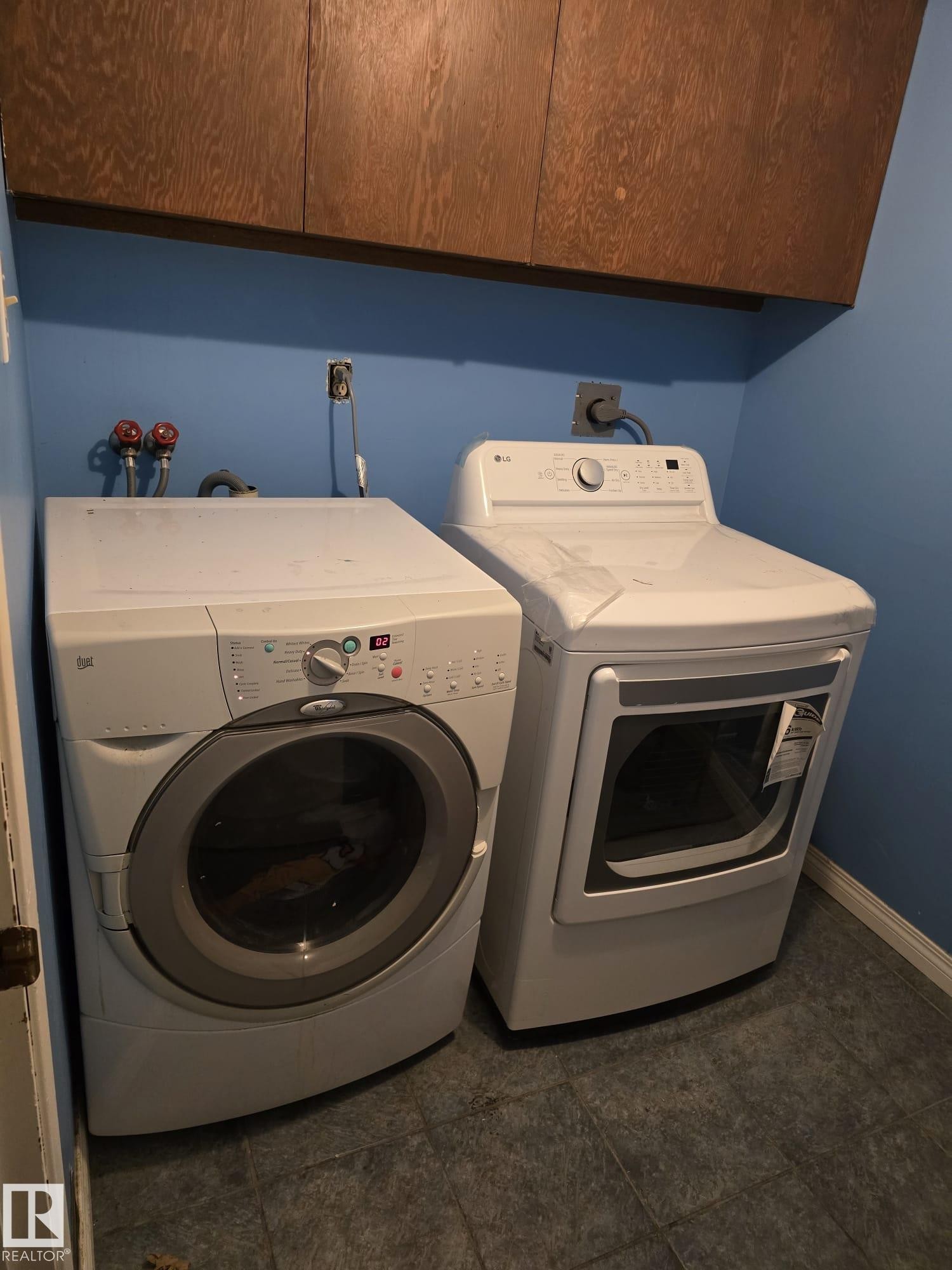 Dedicated laundry area featuring overhead wood cabinetry and tile flooring - 11927 85 Street Nw, Edmonton, AB - Indoor Photo Showing Laundry Room