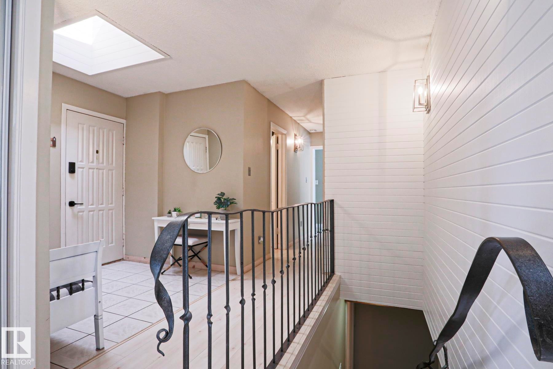 Entryway with a skylight, paneled door with matte black hardware, and square tile flooring - 1214 85 Street Nw, Edmonton, AB - Indoor Photo Showing Other Room