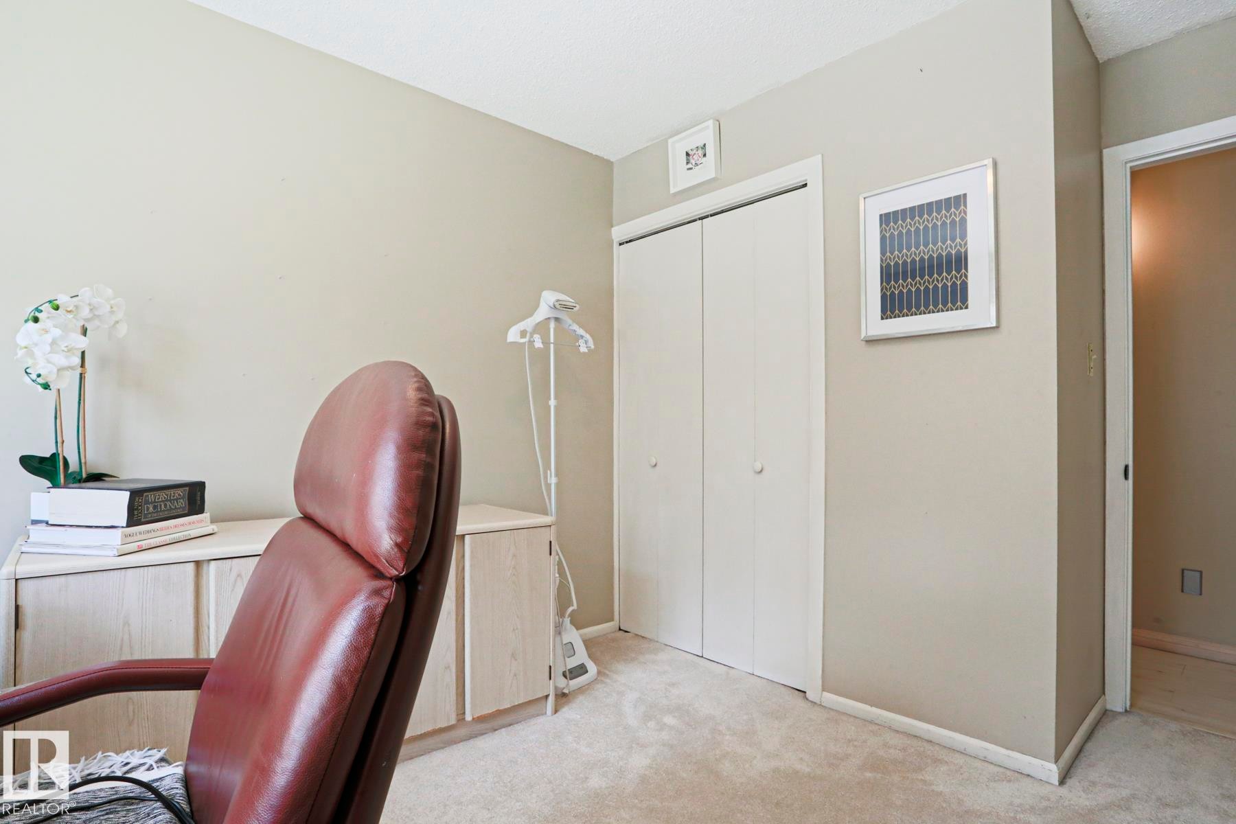 Carpeted interior space featuring a double-door closet, neutral wall tones, and white baseboards - 1214 85 Street Nw, Edmonton, AB - Indoor