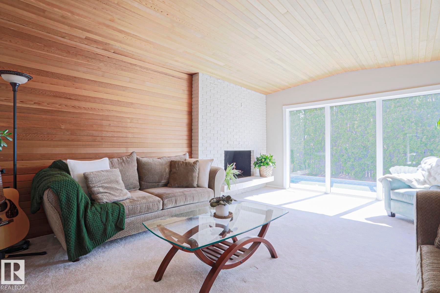 Living area with wood-paneled accent wall and matching wood-paneled ceiling - 1214 85 Street Nw, Edmonton, AB - Indoor Photo Showing Living Room