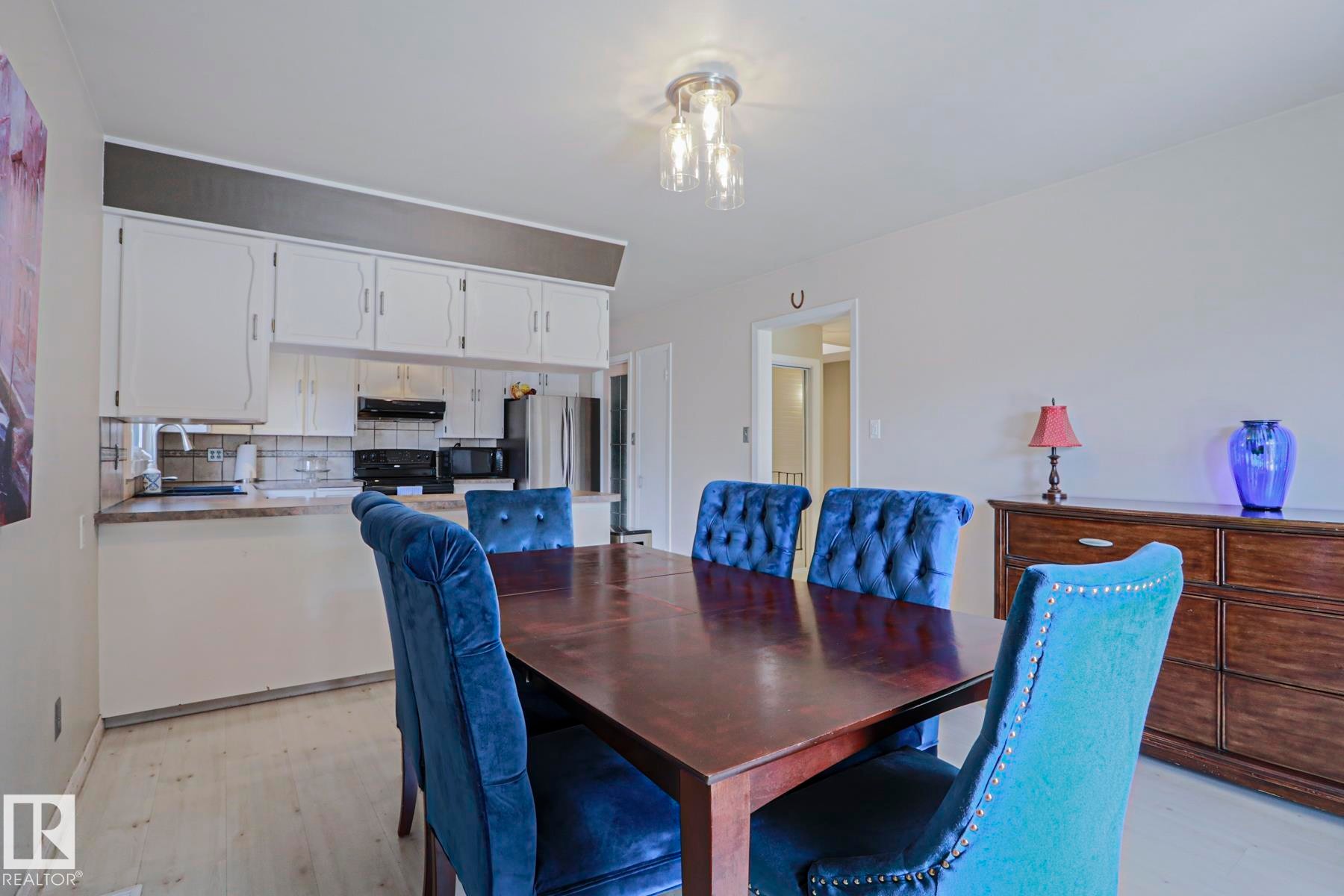Dining area featuring light wood-finish flooring and a contemporary overhead light fixture - 1214 85 Street Nw, Edmonton, AB - Indoor Photo Showing Dining Room
