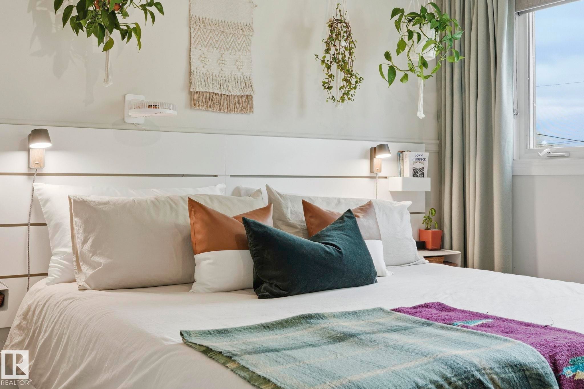 White paneled headboard featuring integrated wall-mounted task lighting and shelving - 4 Langley Dr, Fort Saskatchewan, AB - Indoor Photo Showing Bedroom