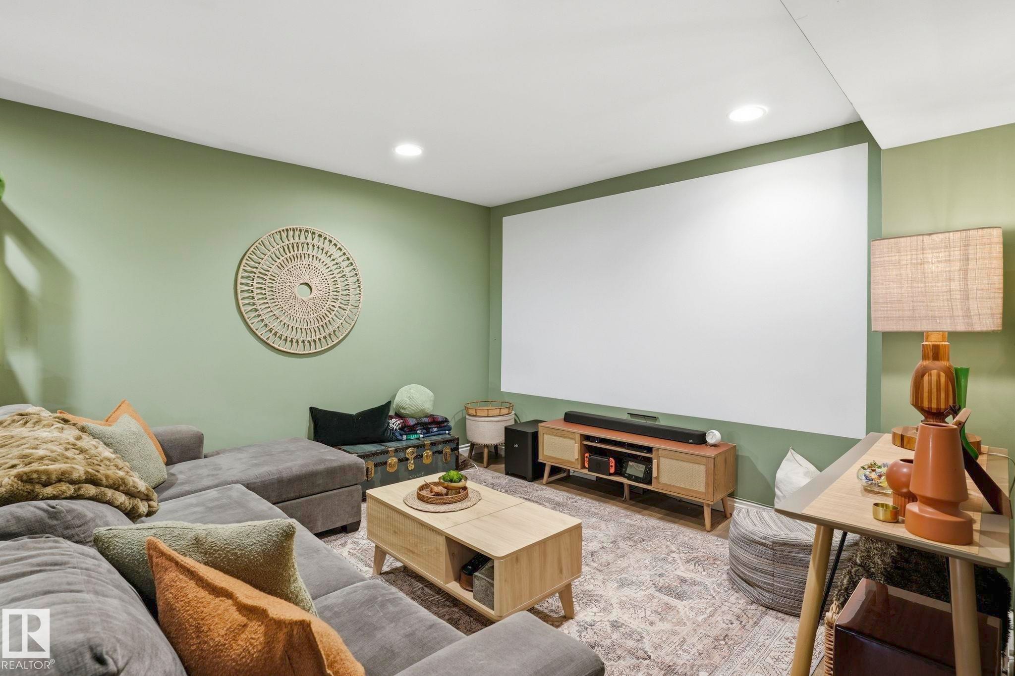 Spacious entertainment room featuring a large projection screen, recessed lighting, and a neutral color palette - 4 Langley Dr, Fort Saskatchewan, AB - Indoor