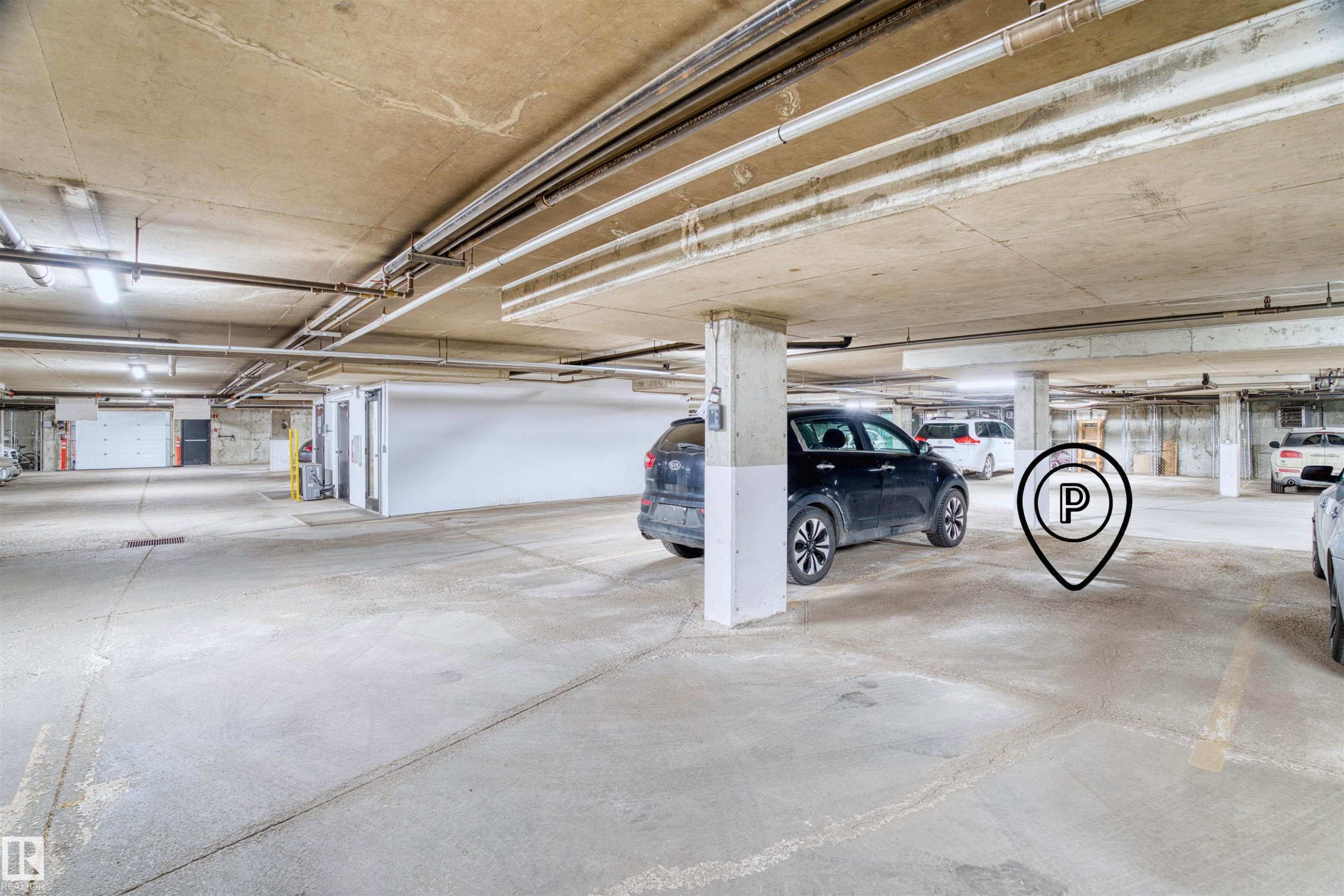 Dedicated parking space within a subterranean garage, featuring concrete flooring and overhead lighting - 205 10939 82 Avenue, Edmonton, AB - Indoor Photo Showing Garage