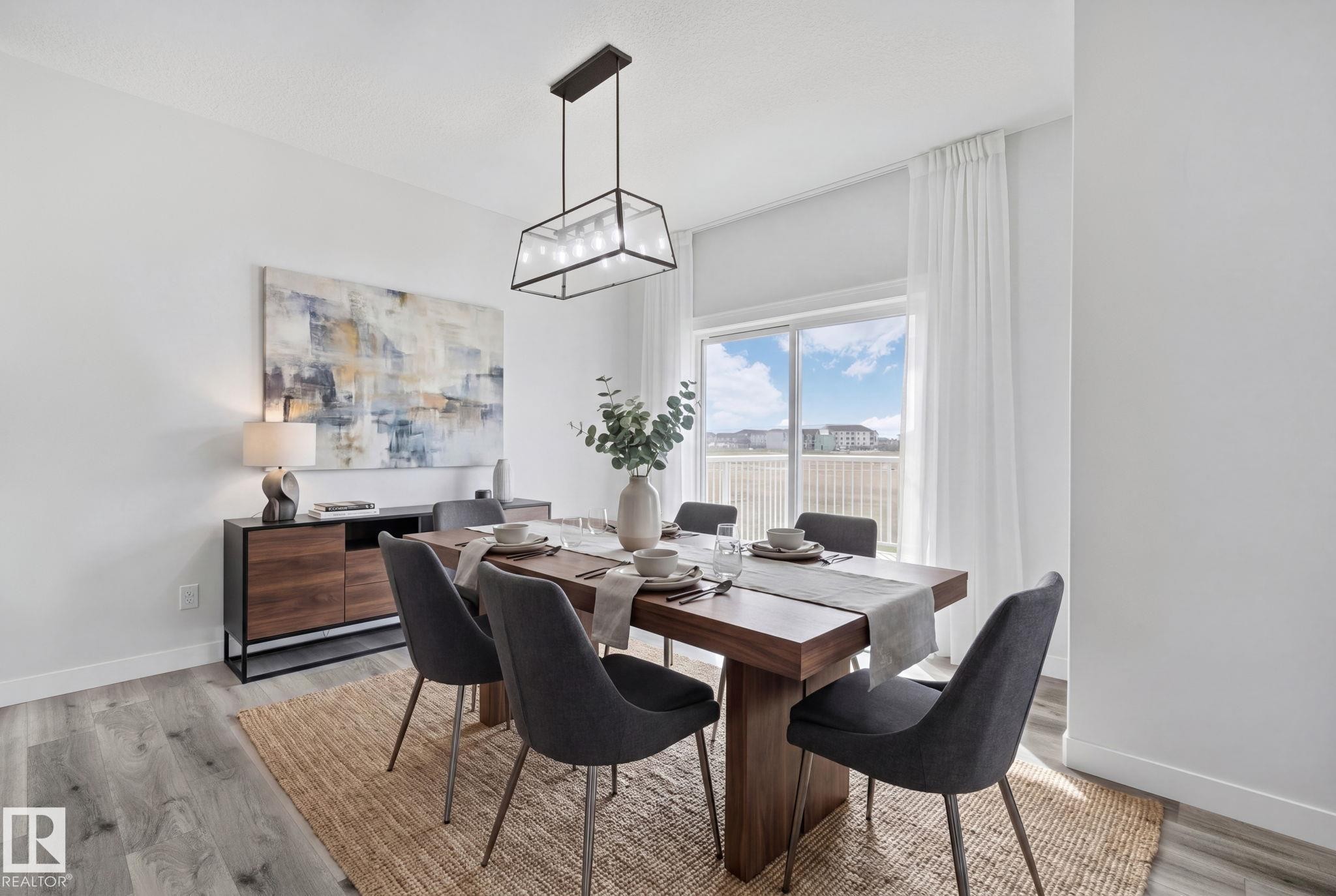 Spacious room featuring light wood-finish flooring, a contemporary linear chandelier, and a large sliding glass door - 334 Aston Close, Leduc, AB - Indoor Photo Showing Dining Room