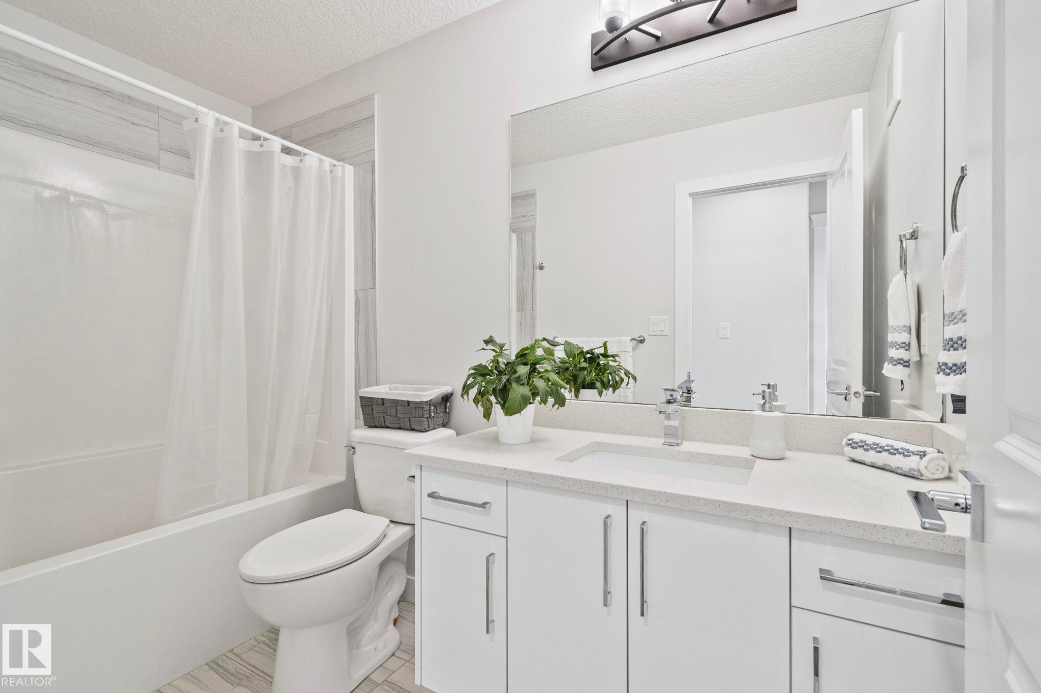 Bathroom featuring a white vanity with a light-colored countertop, an integrated sink, and chrome fixtures - 334 Aston Close, Leduc, AB - Indoor Photo Showing Bathroom