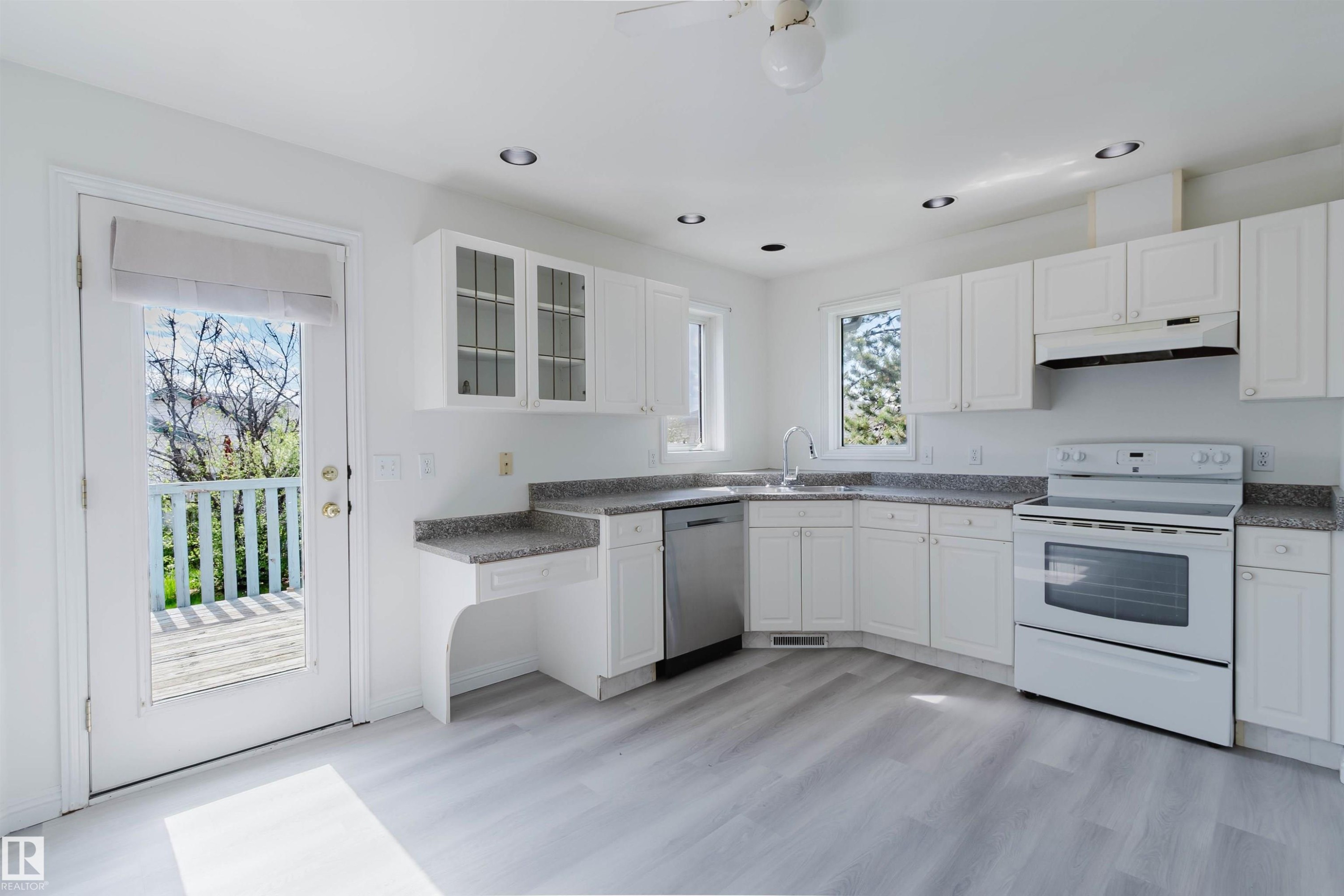 Modern kitchen featuring white cabinetry, grey speckled countertops, stainless steel dishwasher, white range, and recessed lighting - 13755 131B Avenue, Edmonton, AB - Indoor Photo Showing Kitchen