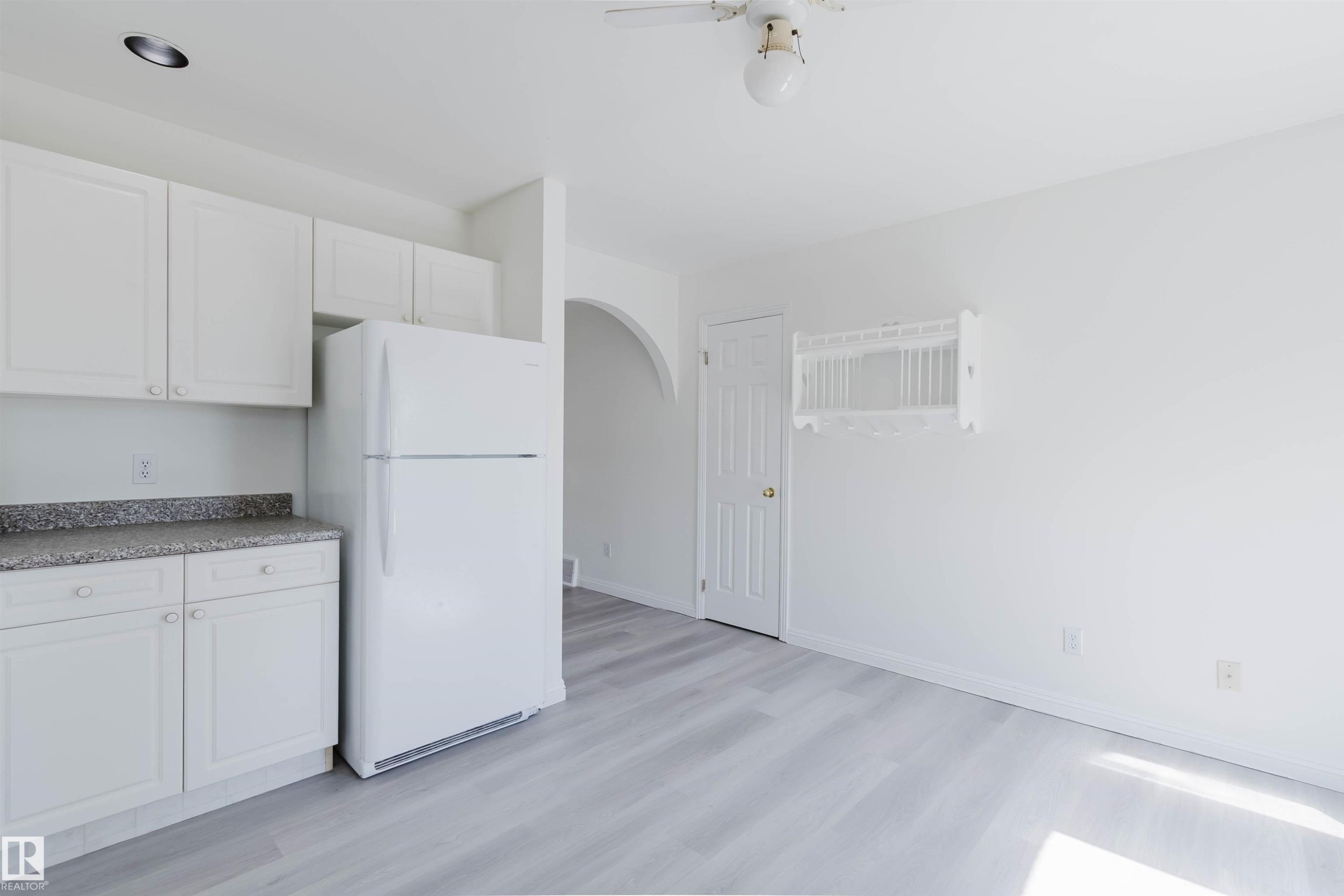 Kitchenette featuring a white refrigerator and white cabinetry with speckled countertops - 13755 131B Avenue, Edmonton, AB - Indoor Photo Showing Kitchen