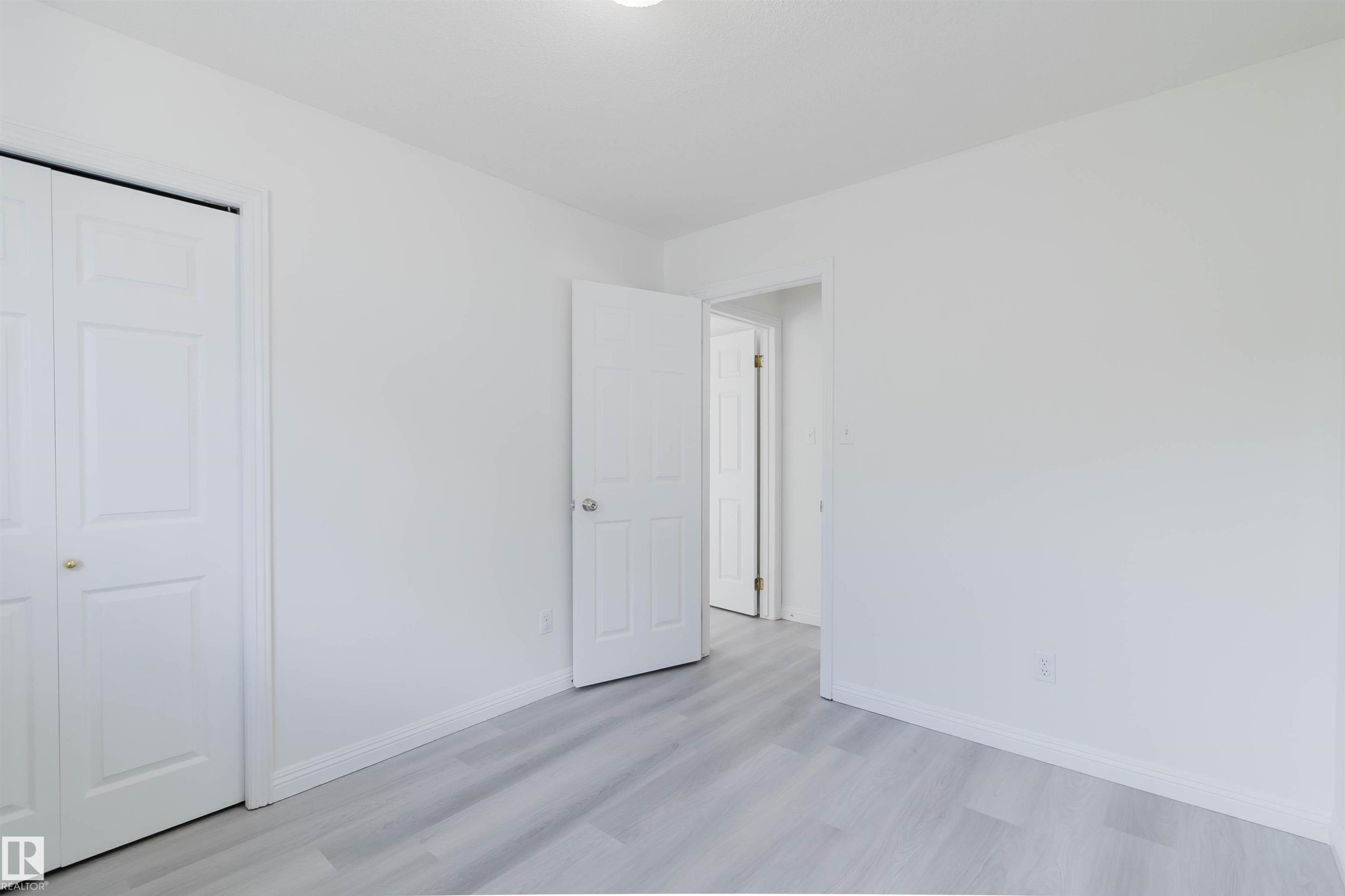White walls complementing gray wood-finish flooring - 13755 131B Avenue, Edmonton, AB - Indoor Photo Showing Other Room