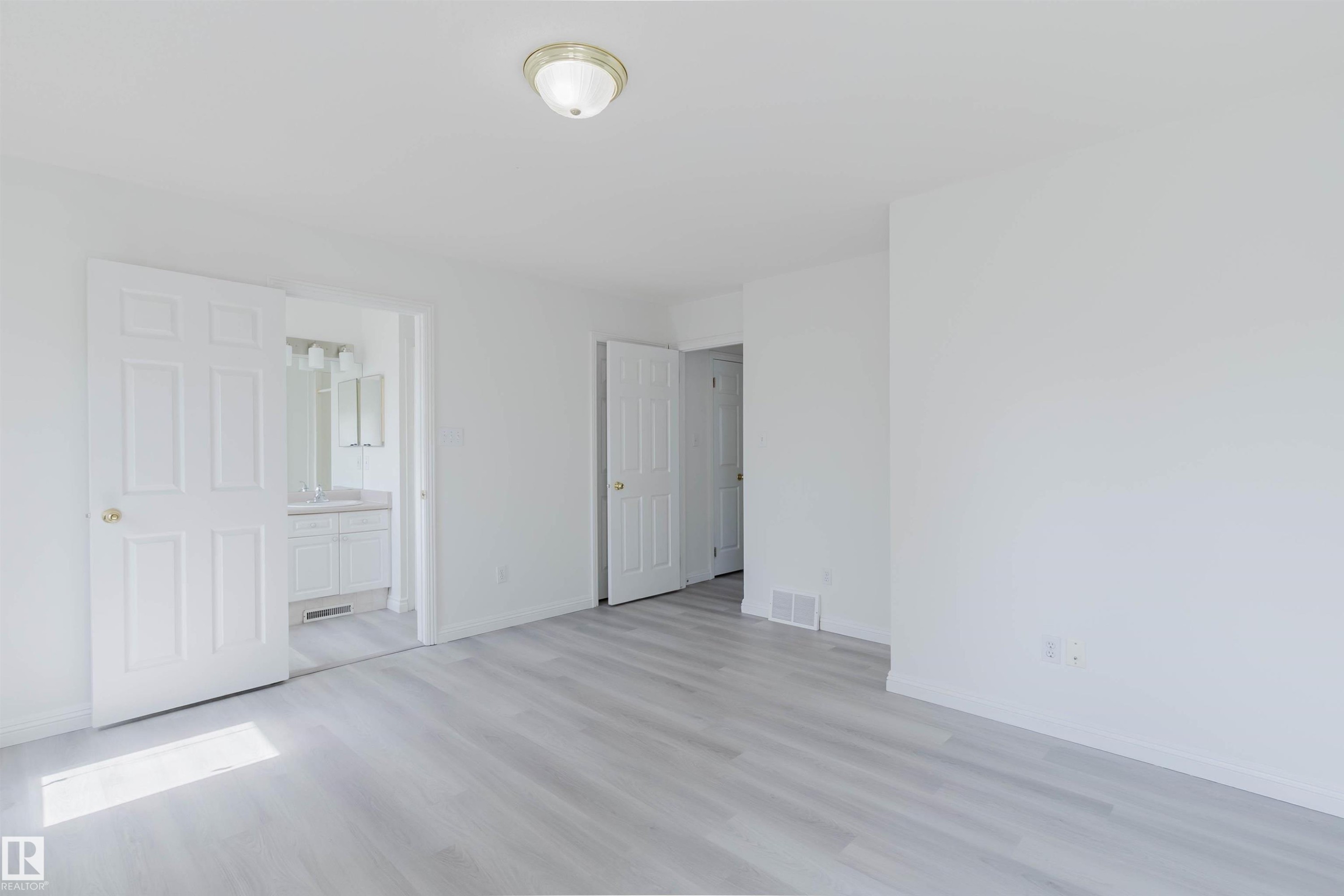 Spacious interior featuring light wood-finish flooring, white walls, and a ceiling-mounted light fixture - 13755 131B Avenue, Edmonton, AB - Indoor Photo Showing Other Room