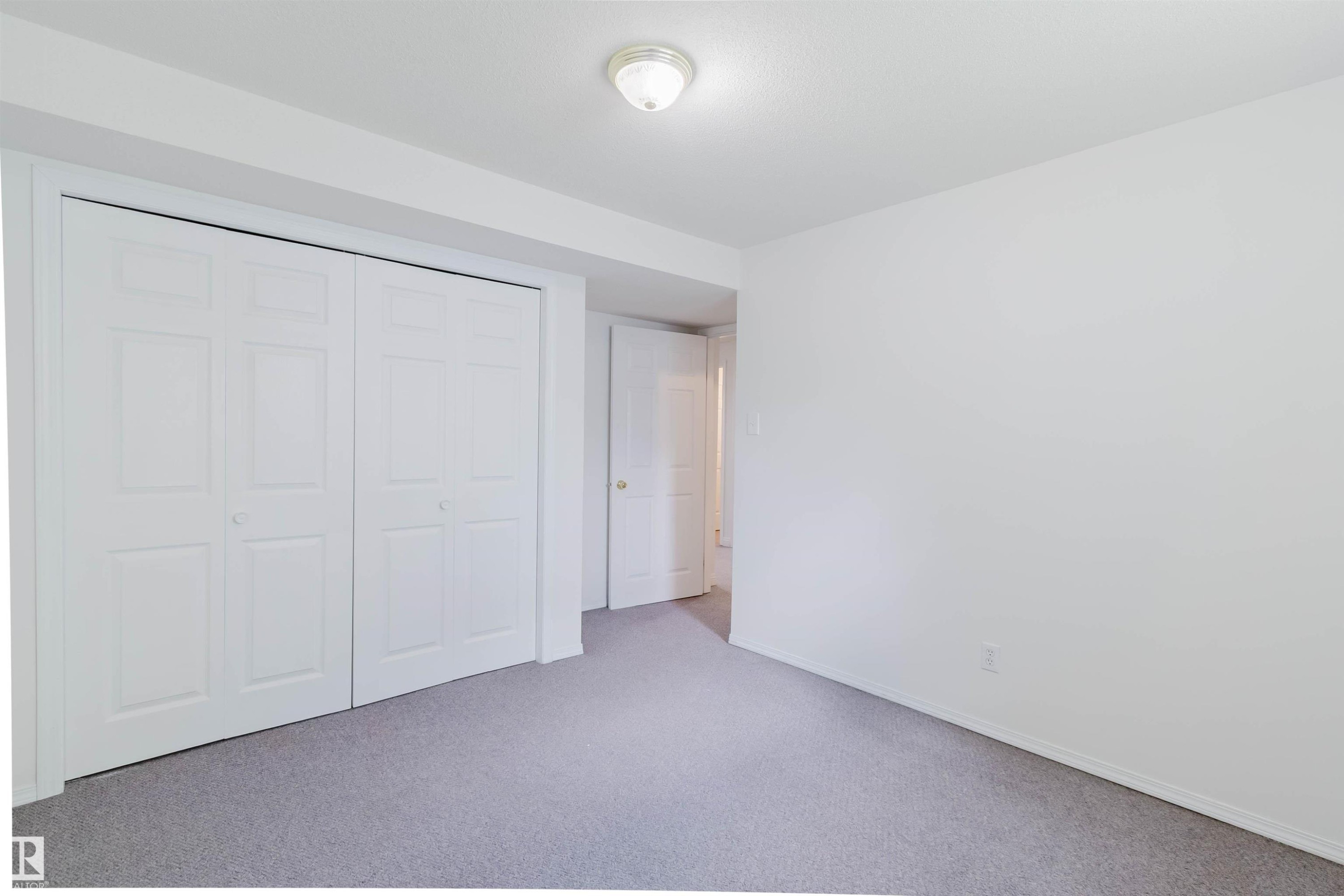 Bedroom featuring light gray carpeting, white walls, and a white bi-fold closet door system - 13755 131B Avenue, Edmonton, AB - Indoor Photo Showing Other Room