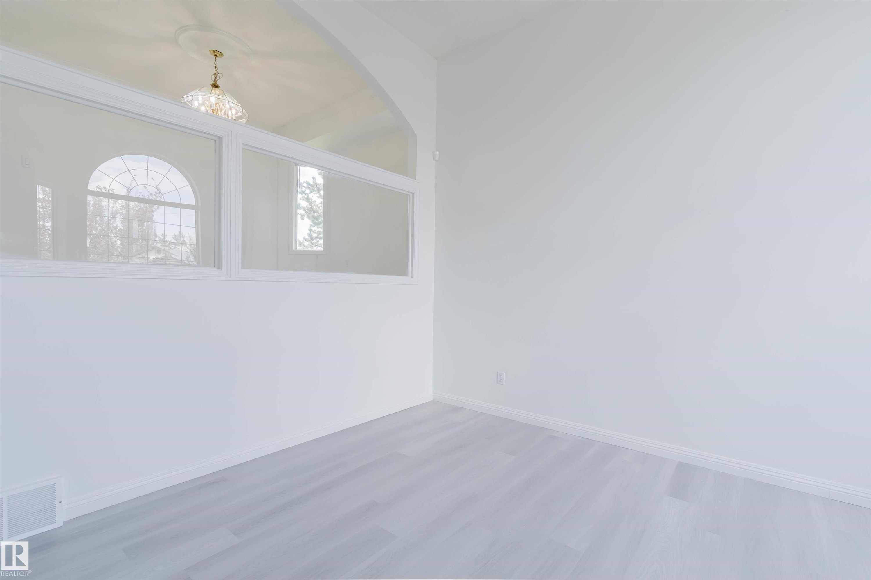 Light gray wood-finish flooring complements white walls - 13755 131B Avenue, Edmonton, AB - Indoor Photo Showing Other Room