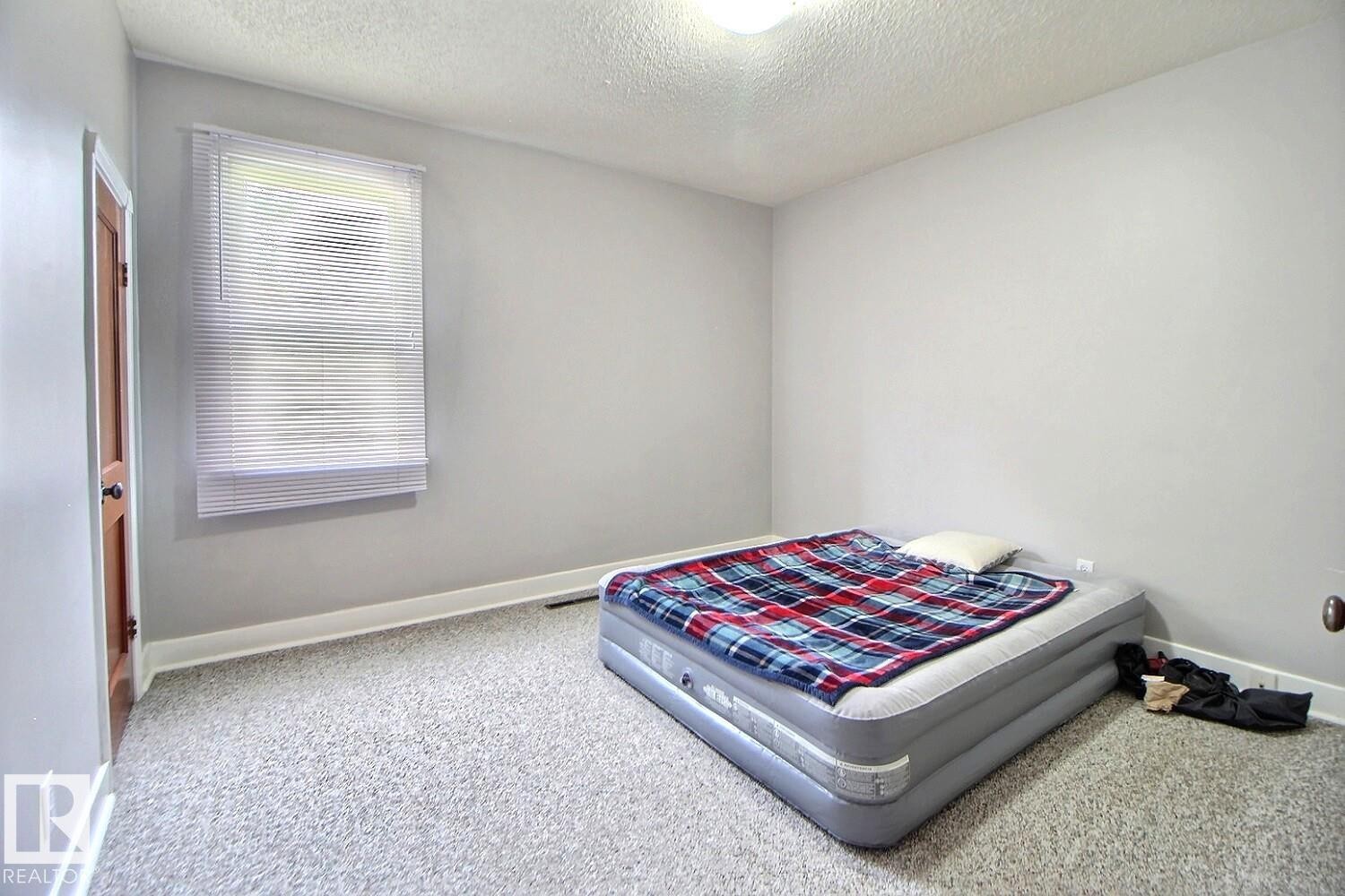 Window with horizontal blinds, light gray wall paint, and light-colored carpeting - 11626 87 Street Nw, Edmonton, AB - Indoor Photo Showing Bedroom