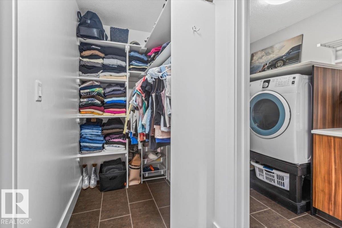 Walk-in closet with built-in shelving and hanging rods - 219 Cranberry Bend, Fort Saskatchewan, AB - Indoor Photo Showing Laundry Room