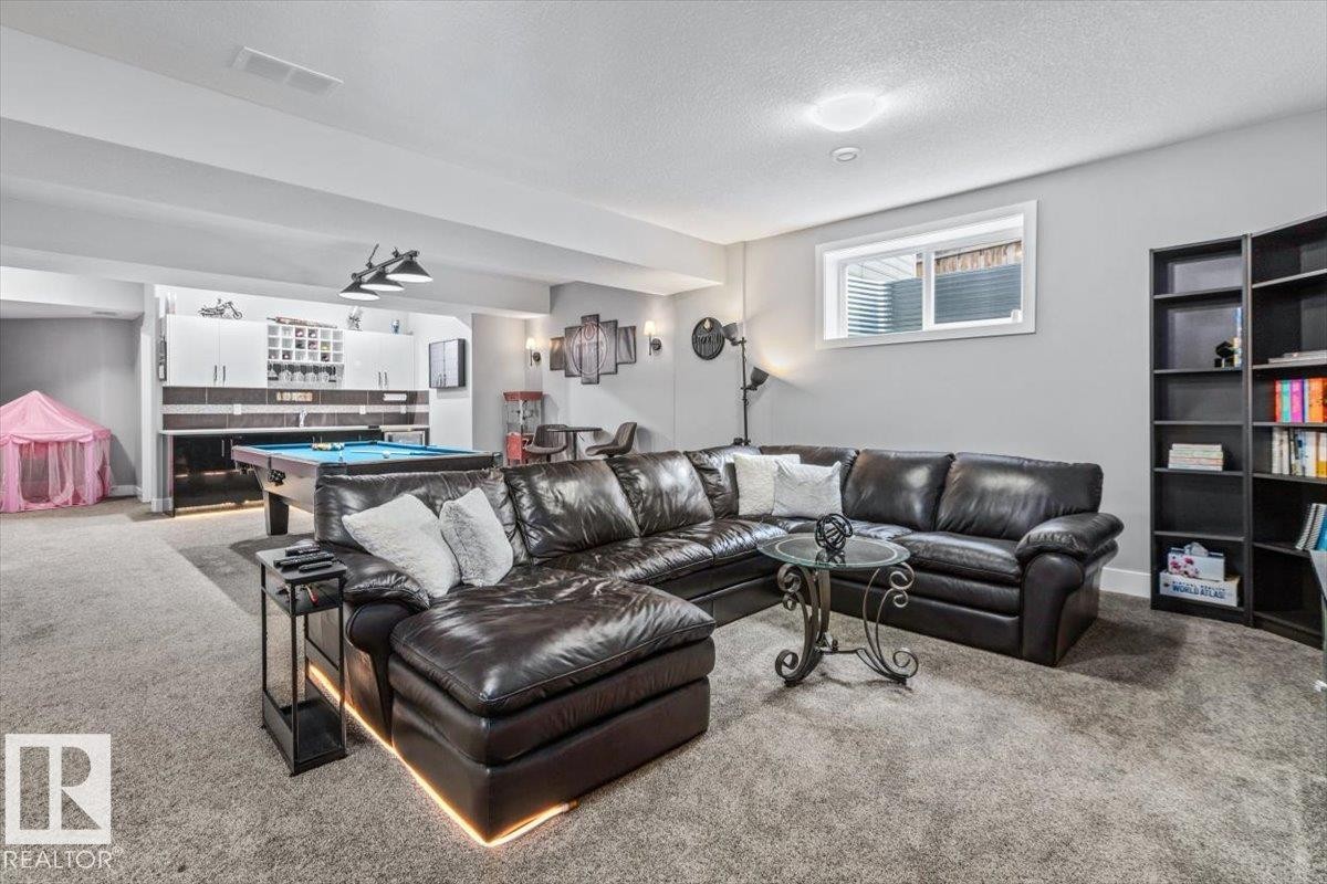 Finished lower level featuring recessed lighting, a built-in wet bar, a window, and plush carpeting - 219 Cranberry Bend, Fort Saskatchewan, AB - Indoor Photo Showing Living Room