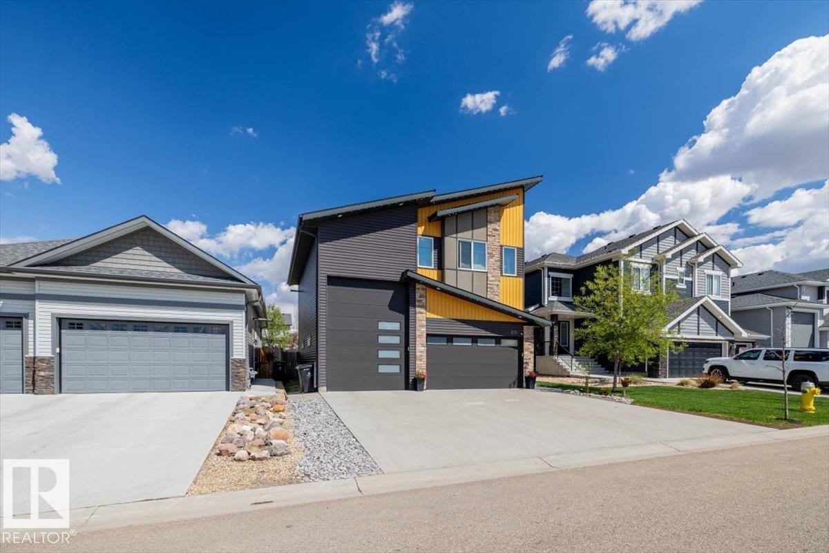 Modern exterior with a striking yellow and gray color palette, featuring an asymmetrical roofline - 219 Cranberry Bend, Fort Saskatchewan, AB - Outdoor With Facade