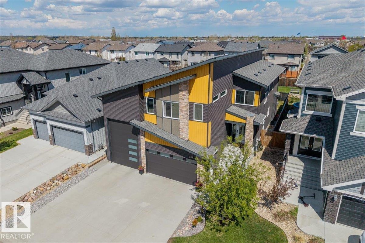 Contemporary exterior with dark siding, yellow accents, and stone detailing - 219 Cranberry Bend, Fort Saskatchewan, AB - Outdoor