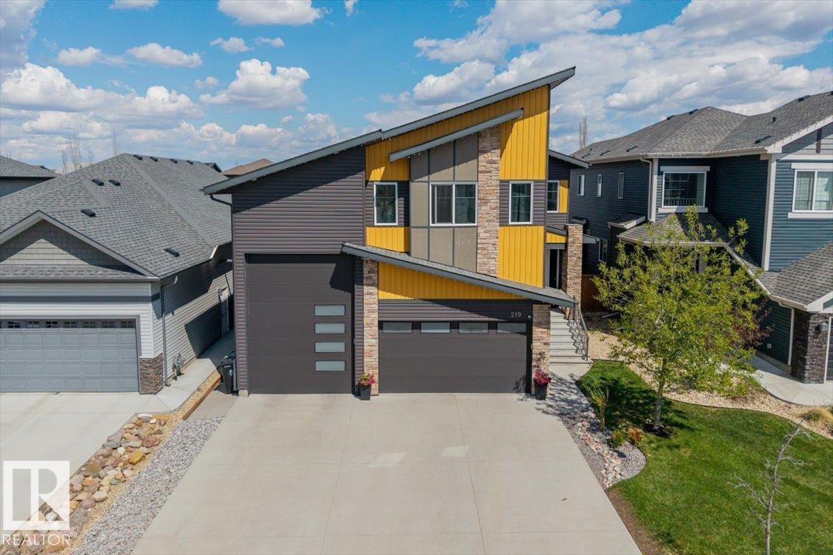 Modern architectural home with a striking facade, featuring varied siding in charcoal and yellow tones - 219 Cranberry Bend, Fort Saskatchewan, AB - Outdoor
