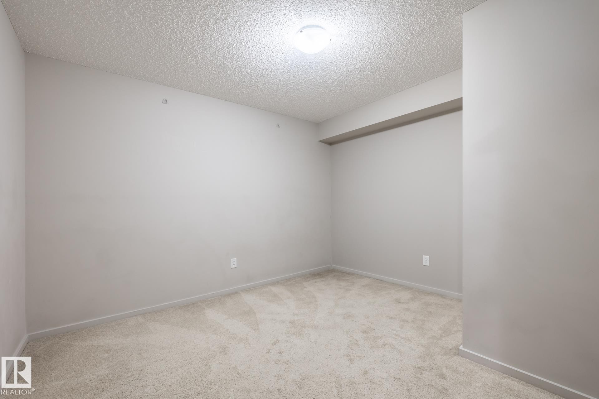 Carpeted room with light gray walls, textured ceiling, recessed ceiling fixture, and baseboard trim - 131 344 Windermere Road, Edmonton, AB - Indoor Photo Showing Other Room