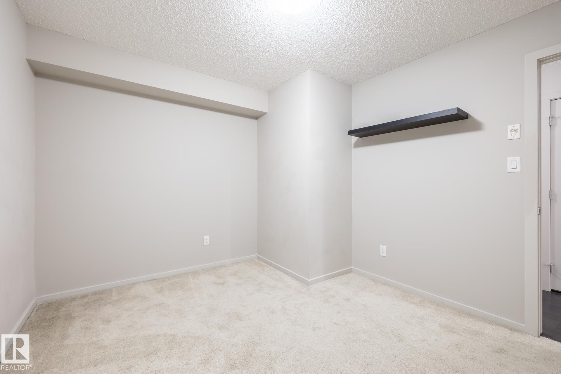 Neutral-toned room featuring light-colored carpet flooring and a textured ceiling - 131 344 Windermere Road, Edmonton, AB - Indoor Photo Showing Other Room