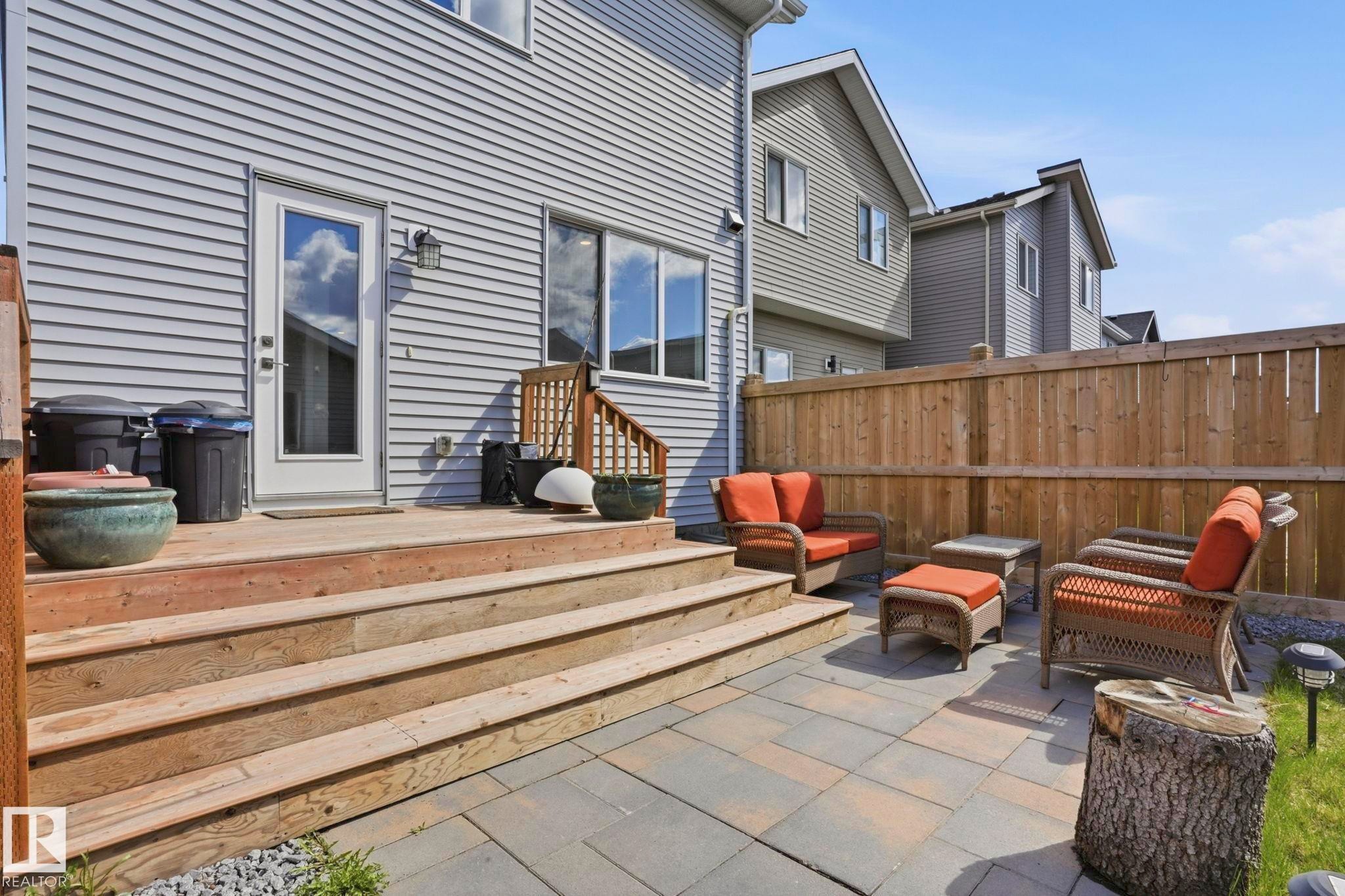 Rear exterior featuring light grey horizontal siding, a multi-level wood deck, and a paver patio area - 2116 159 Street, Edmonton, AB - Outdoor With Deck Patio Veranda With Exterior