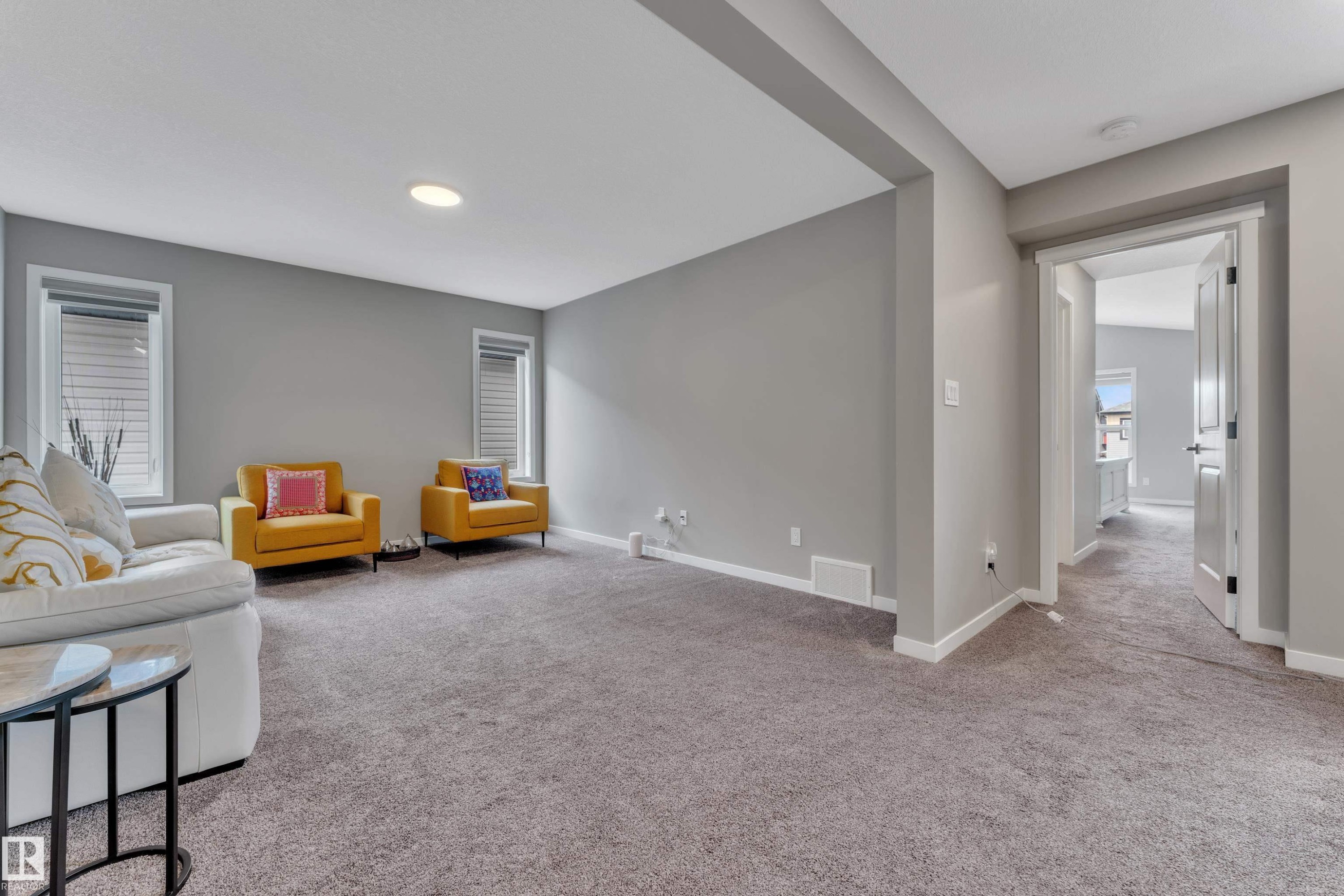 The living area features neutral gray walls, light gray carpet, and recessed lighting - 21853 98A Avenue, Edmonton, AB - Indoor
