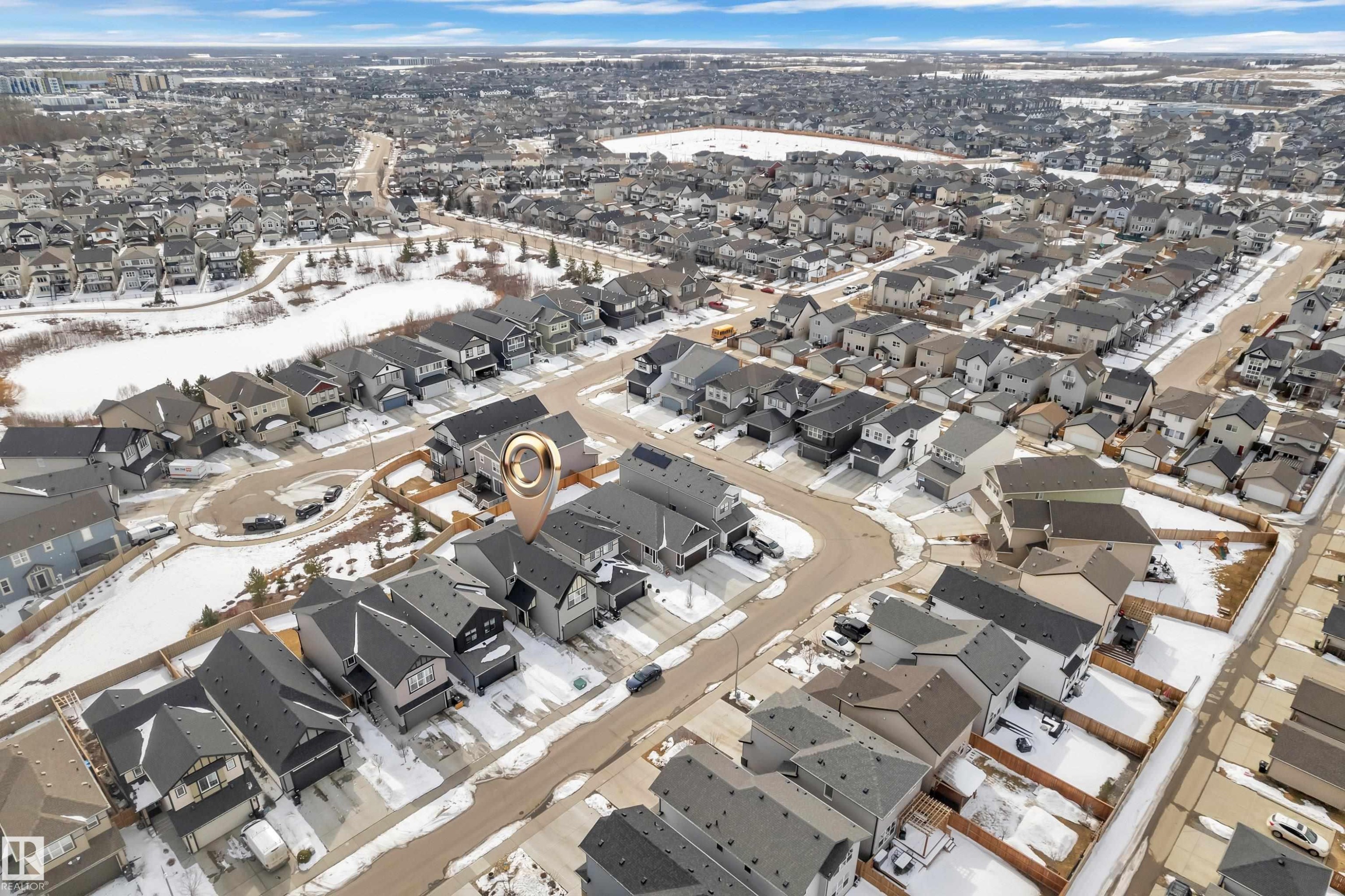 Aerial view of the property and its surrounding residential area, featuring a body of water in the background - 21853 98A Avenue, Edmonton, AB - With View